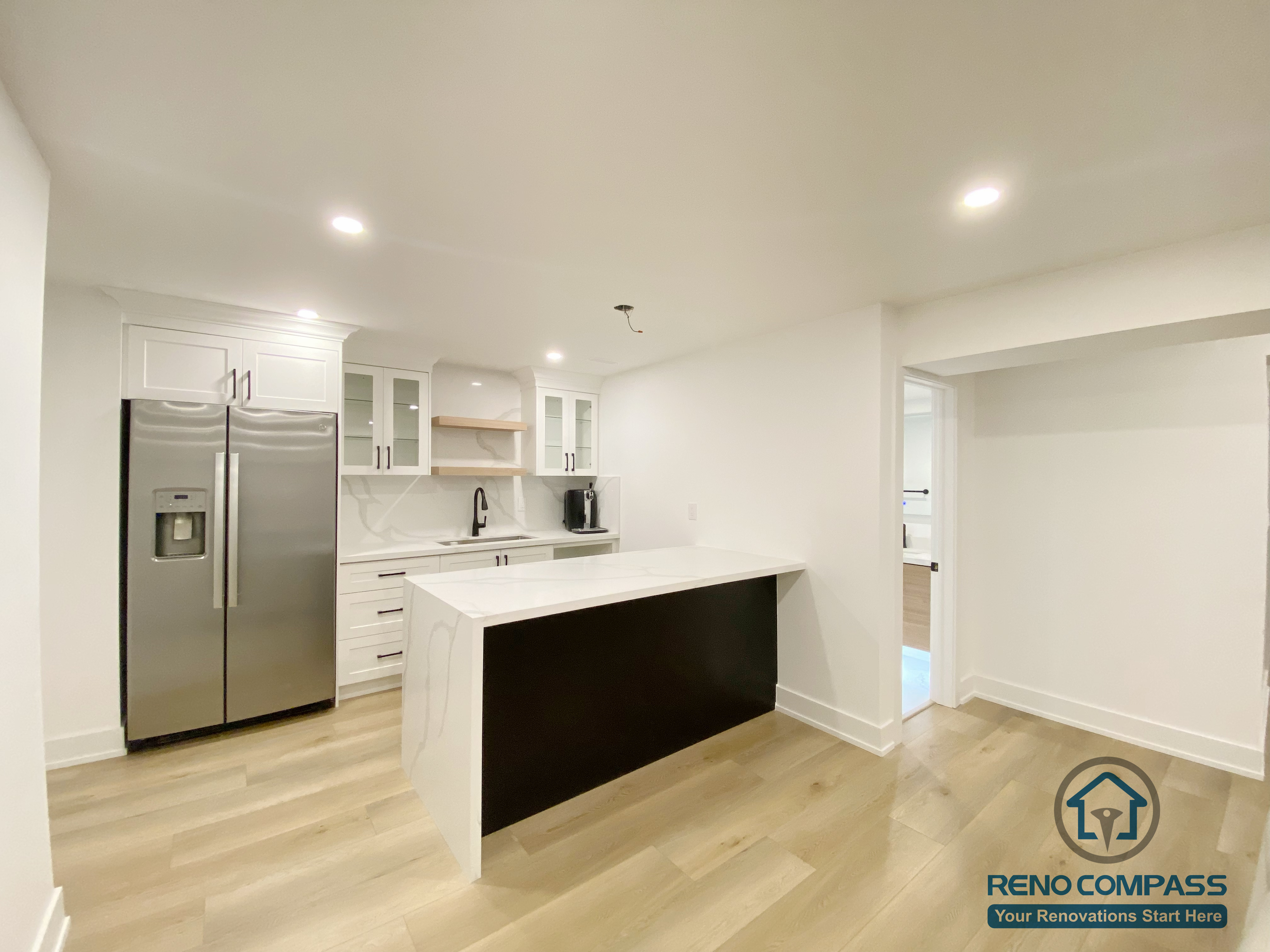 This modern basement kitchen includes a functional island layout, clean cabinetry, and efficient lighting. Designed to support entertaining and everyday use, the space seamlessly connects with the surrounding basement living areas.