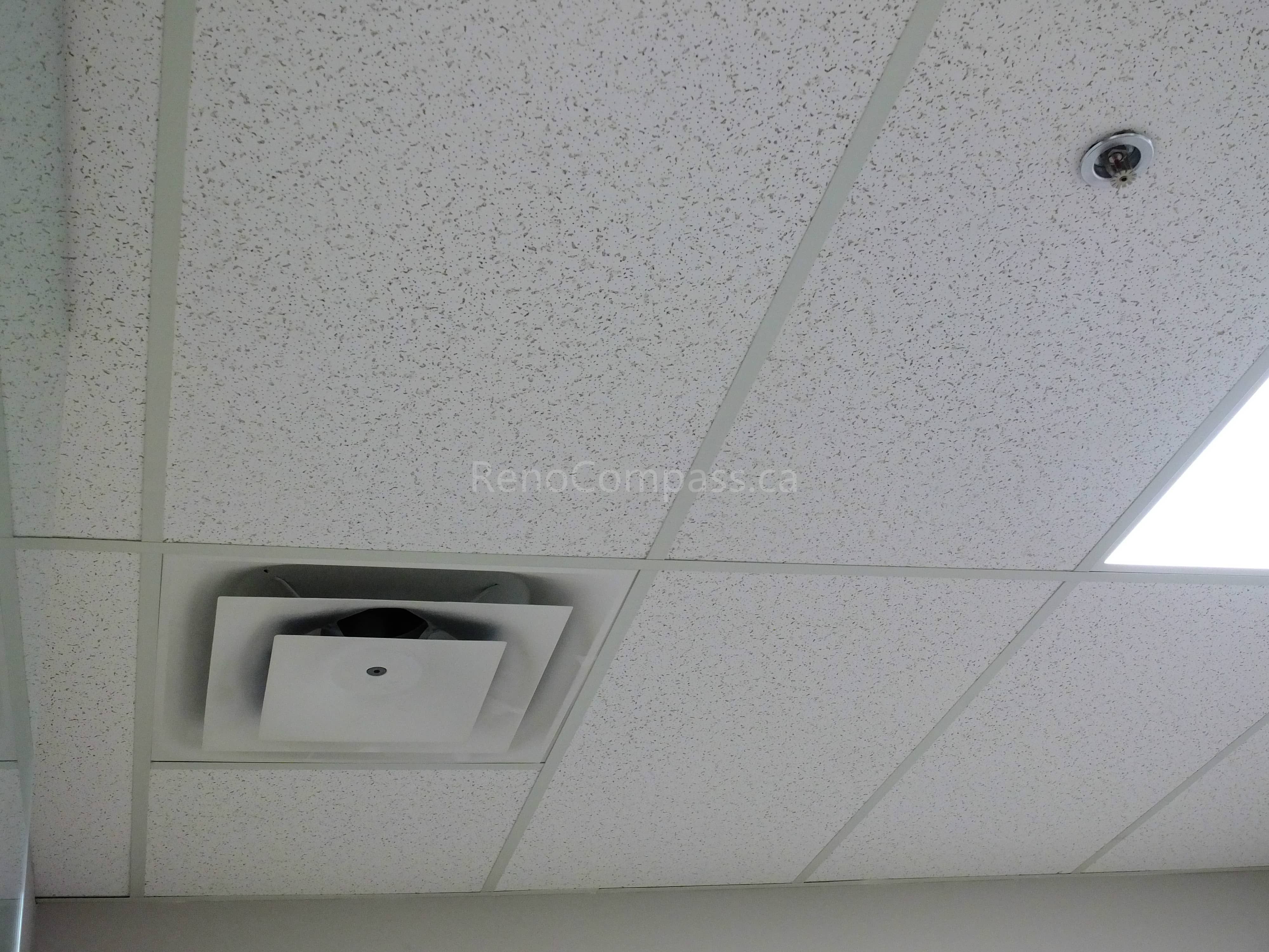 Close-up view of acoustic drop ceiling tiles with integrated HVAC air vent and recessed lighting in a North York office commercial renovation. This office interior upgrade enhances air circulation, sound control, and ceiling finish quality, delivered by an experienced Toronto renovation company specializing in commercial office spaces.