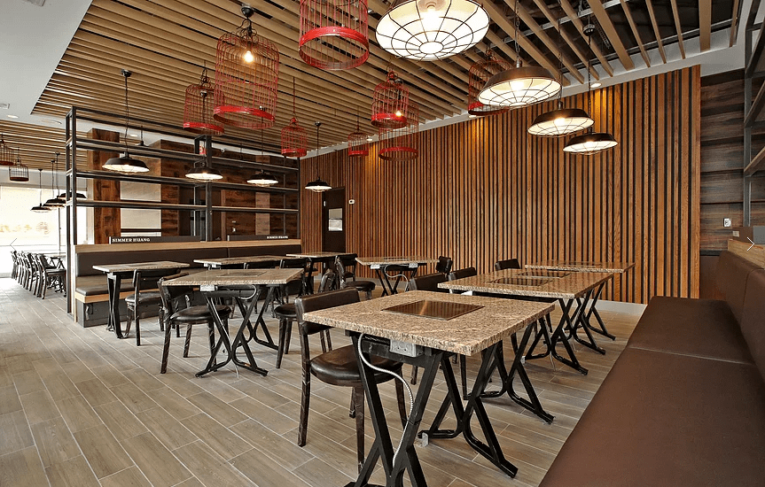 Modern restaurant commercial renovation in Markham featuring custom wood ceiling design, decorative lighting, contemporary wall paneling, and functional dining layout. This professionally designed space enhances customer experience and operational efficiency for restaurant businesses. Completed by a trusted Toronto renovation company, Reno Compass Inc., specializing in commercial and restaurant renovation projects across the GTA.