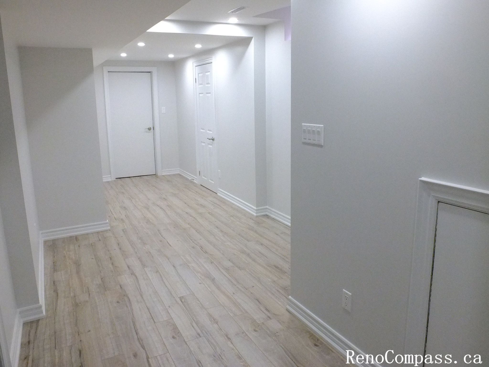 Smooth finished basement ceiling and bright lighting add depth to this Richmond Hill renovation by Reno Compass Inc., professional Toronto Renovation Company.