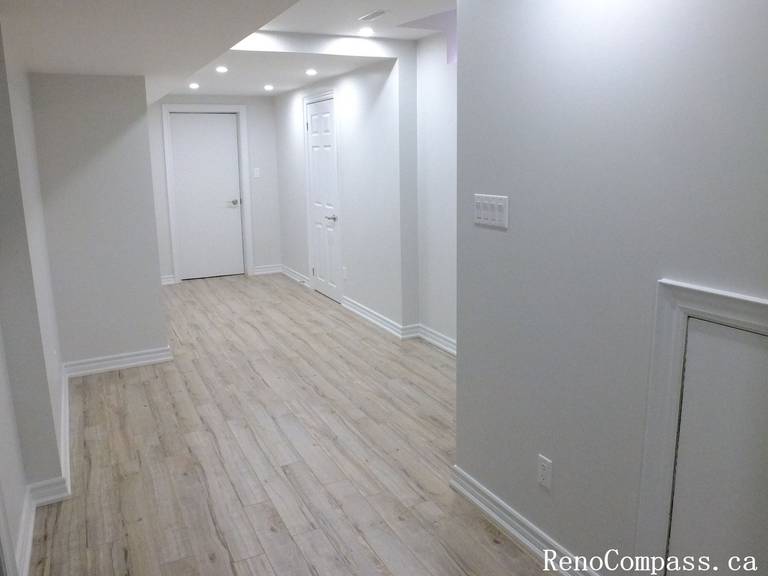 Smooth finished basement ceiling and bright lighting add depth to this Richmond Hill renovation by Reno Compass Inc., professional Toronto Renovation Company.