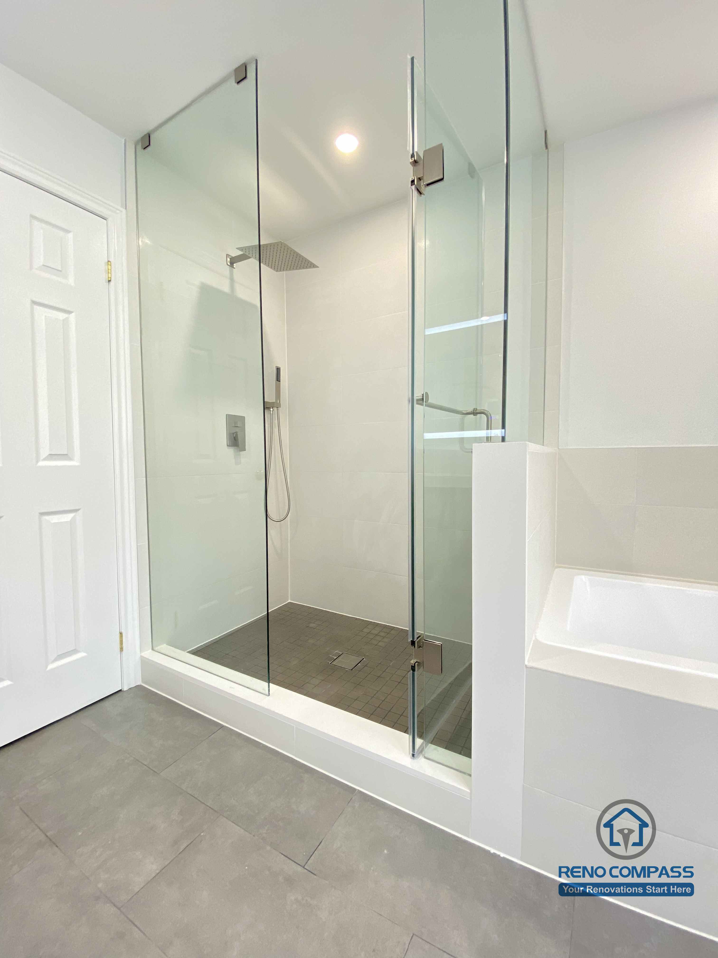 This Markham bathroom renovation showcases a modern glass-enclosed shower paired with an integrated bathtub layout. The frameless glass panels, rainfall shower system, and large-format floor tiles create a clean, functional, and space-efficient design. Completed by a professional Toronto renovation company, this bathroom balances comfort, durability, and contemporary aesthetics.