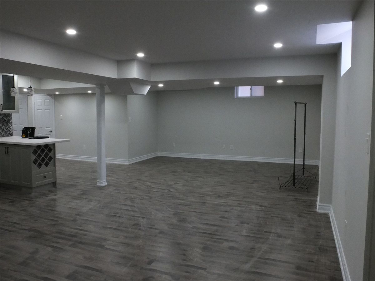 This Scarborough basement renovation project features a modern open-concept layout designed to maximize space, comfort, and functionality. The newly finished basement includes premium moisture-resistant flooring, recessed pot lights for bright and even illumination, and a spacious entertainment area perfect for family gatherings or rental potential. A custom-built bar and storage area enhance both convenience and style, creating a versatile living and leisure space. Completed by a professional Toronto basement renovation company, the project focuses on clean finishes, durable materials, and long-term property value improvement. Contractor: Reno Compass Inc.