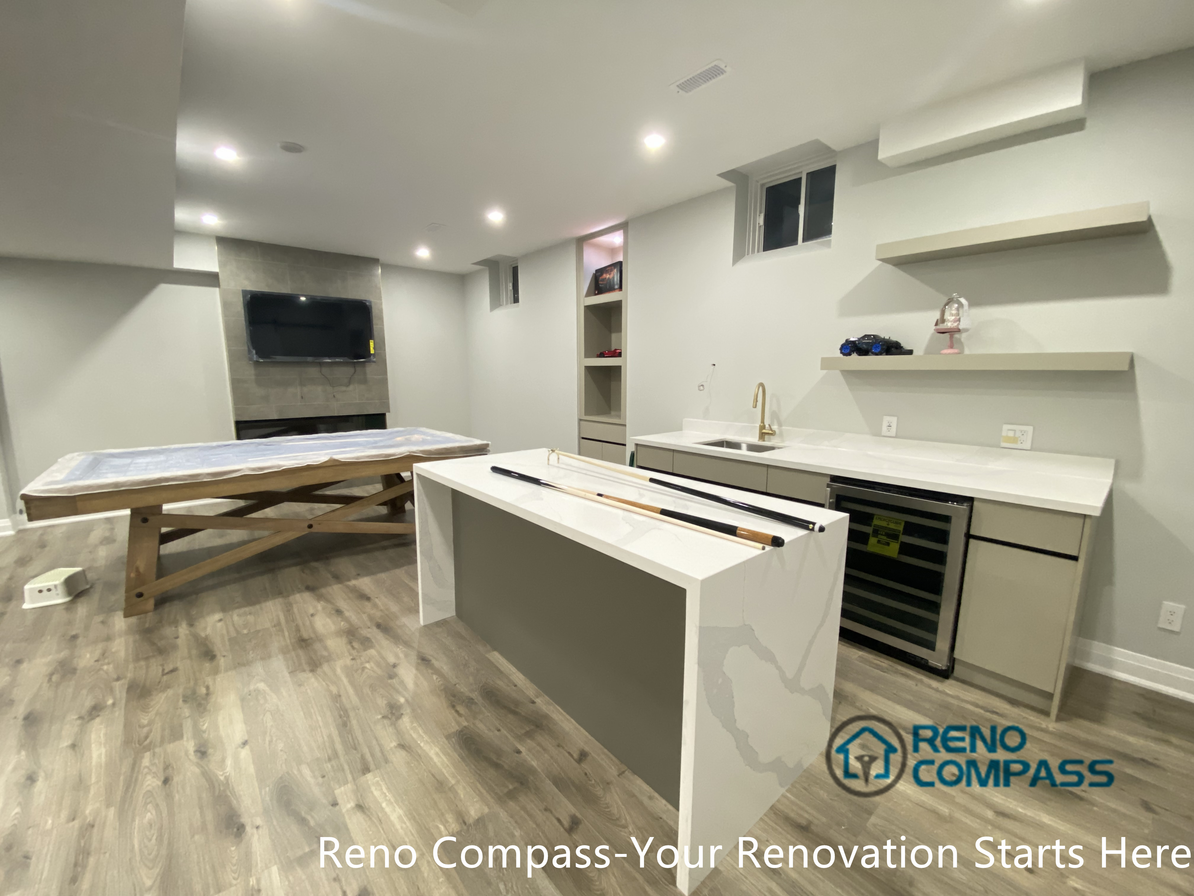 This Newmarket basement renovation features a custom wet bar with a quartz island countertop, built-in wine fridge, open shelving, and integrated sink. Designed and constructed by a trusted Toronto renovation company, the space adds functionality and convenience to the basement, creating an ideal setting for entertaining, casual gatherings, and multi-purpose family use.