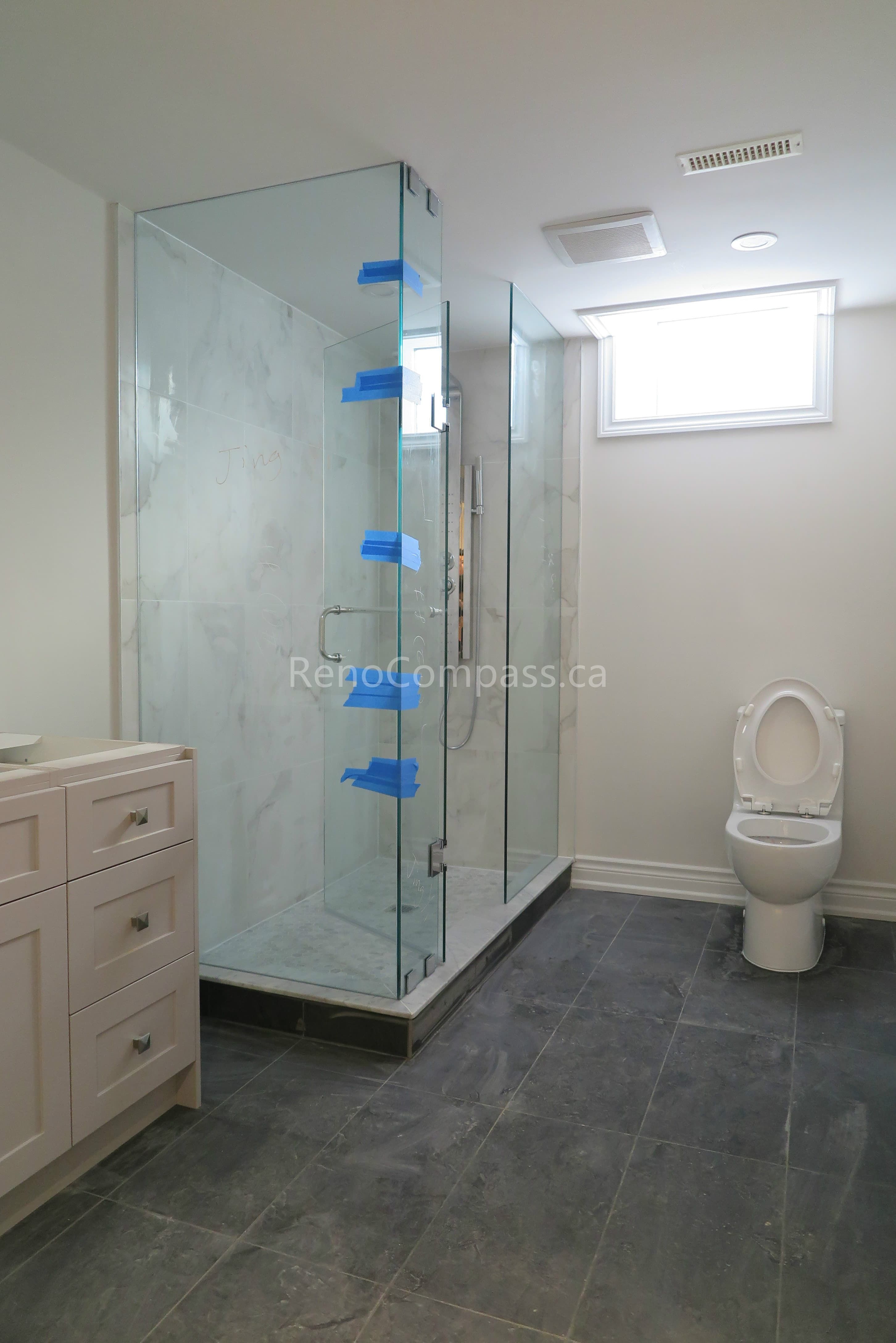 This North York interior renovation showcases a newly upgraded modern bathroom featuring a frameless glass shower enclosure, contemporary vanity cabinetry, and durable floor tiles. Completed by a trusted Toronto renovation company, Reno Compass focuses on clean installation, functional layout design, and high-quality finishes to create a bright, comfortable, and stylish bathroom space for everyday living.