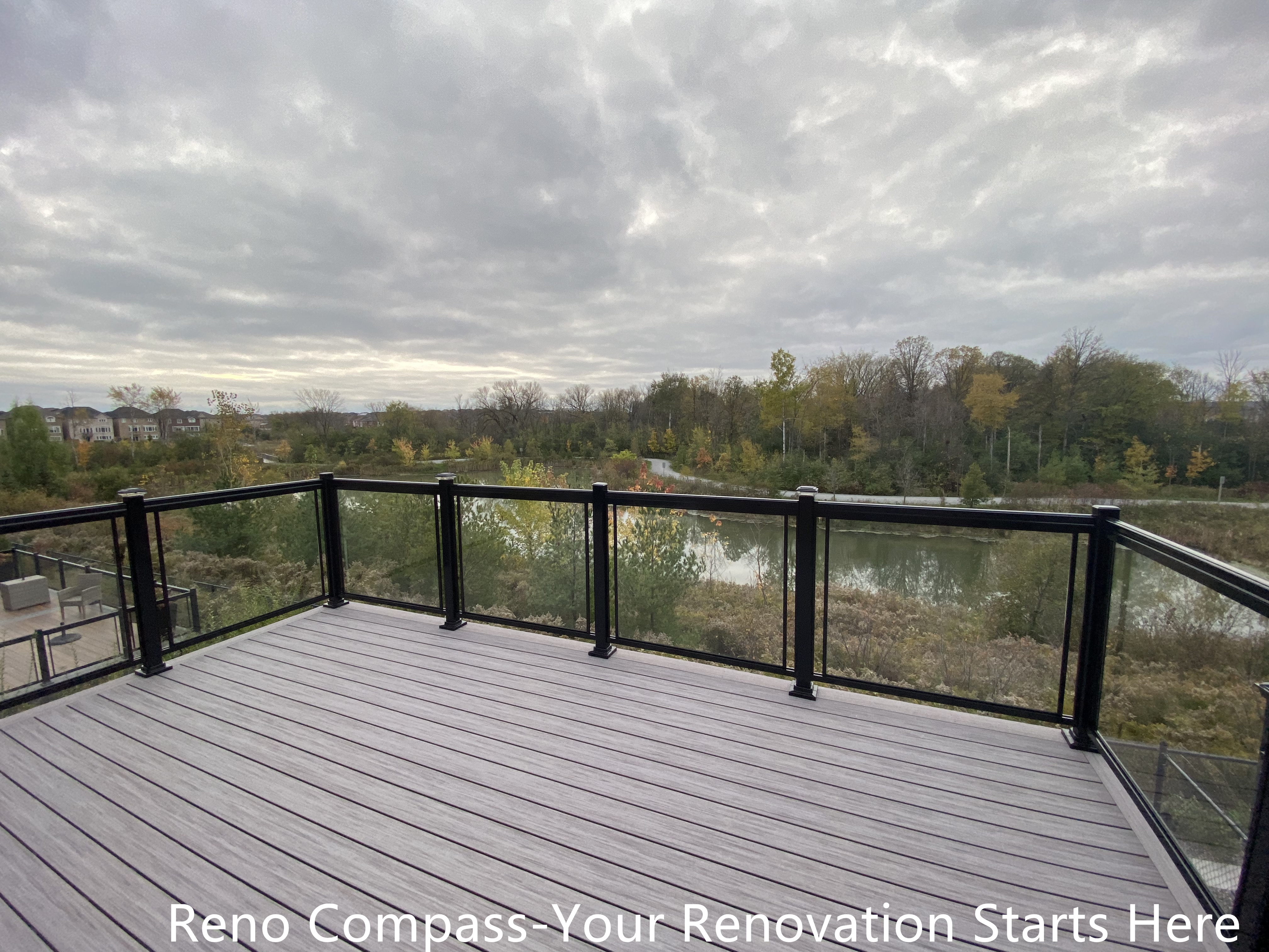 Modern Aurora deck featuring durable wooden flooring and sleek glass railings, designed for outdoor leisure, family gatherings, and seamless integration with the home exterior. Project by Reno Compass Inc.