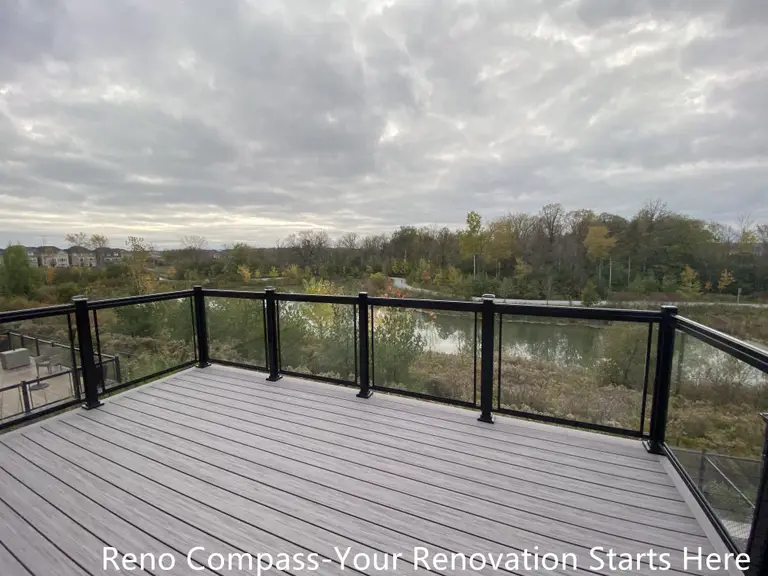 Modern Aurora deck featuring durable wooden flooring and sleek glass railings, designed for outdoor leisure, family gatherings, and seamless integration with the home exterior. Project by Reno Compass Inc.