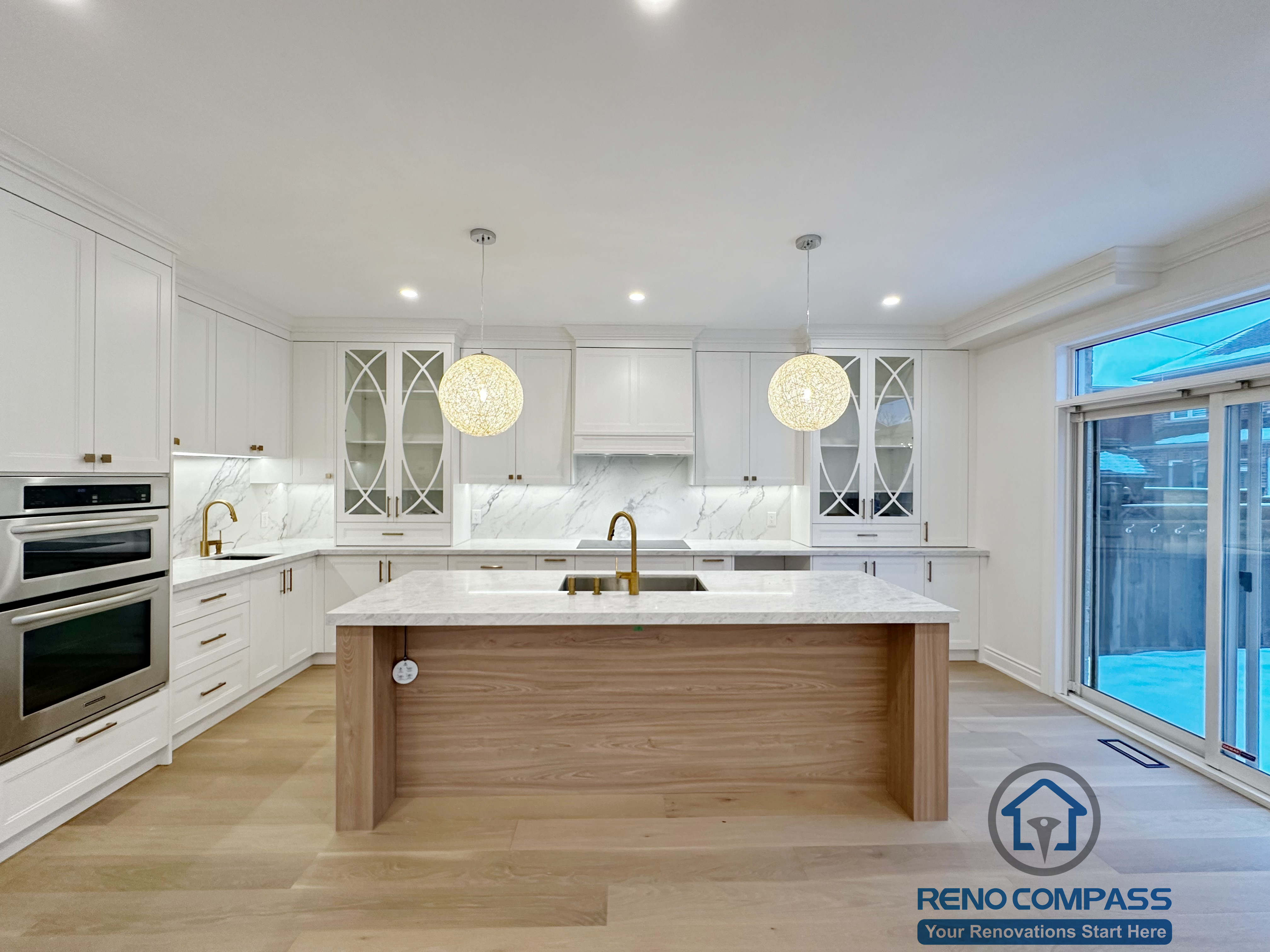 Custom white kitchen completed as part of a Vaughan interior renovation, featuring a large waterfall island with wood paneling, quartz countertops, marble-look backsplash, glass-front cabinets, built-in appliances, and modern pendant lighting. The clean layout and premium finishes highlight the craftsmanship of a professional Toronto renovation company.

这张非常关键，建议你：