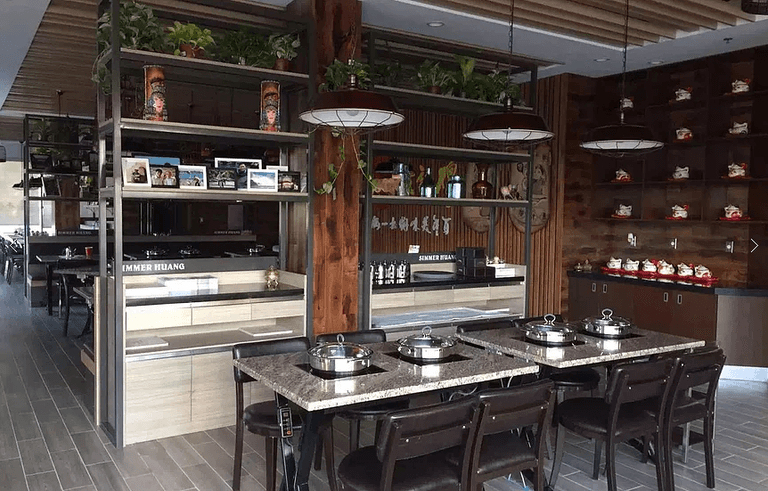 Professional restaurant renovation in Markham featuring custom display shelving, wood ceiling design, decorative lighting, and functional dining layout. This modern commercial interior enhances customer experience, brand presentation, and operational flow. Completed by a trusted Toronto renovation company, Reno Compass Inc., specializing in restaurant and commercial renovation projects across the GTA.