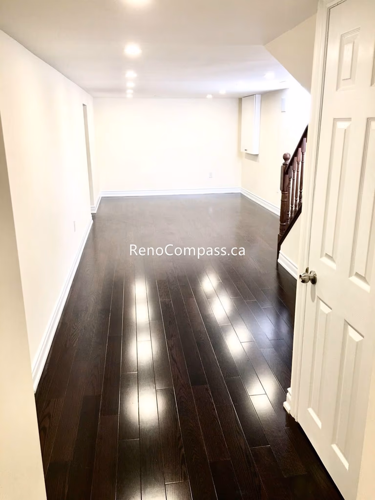 This Toronto basement renovation features newly installed hardwood stairs and matching engineered flooring, creating a clean and modern transition between levels. The upgraded staircase railing and rich wood tones enhance durability, safety, and overall home value. Completed by a professional Toronto renovation company, this project highlights quality craftsmanship and functional design for contemporary basement living spaces.