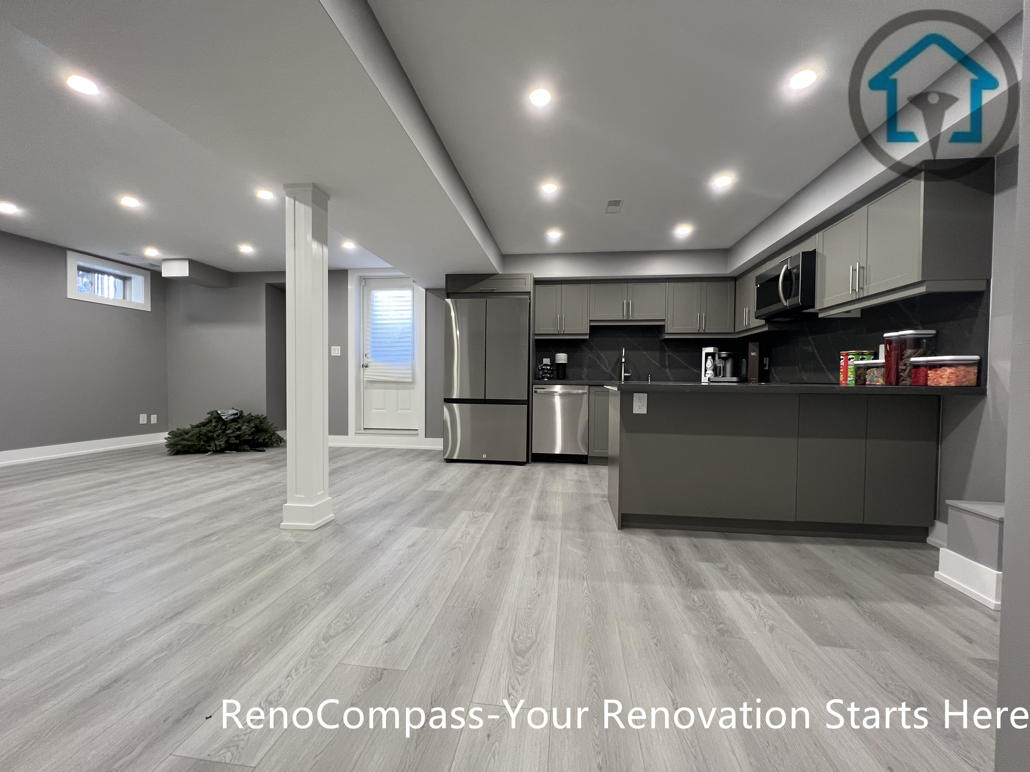 This Vaughan basement renovation showcases a spacious open-concept layout that combines a modern kitchen, dining, and living area within a cohesive lower-level design. The space features custom cabinetry, stainless steel appliances, recessed ceiling lighting, structural support columns, and durable wood-look flooring that enhances brightness and flow. Completed by a Toronto renovation company, this basement renovation emphasizes efficient space planning, modern finishes, and flexible use for everyday living or entertaining.