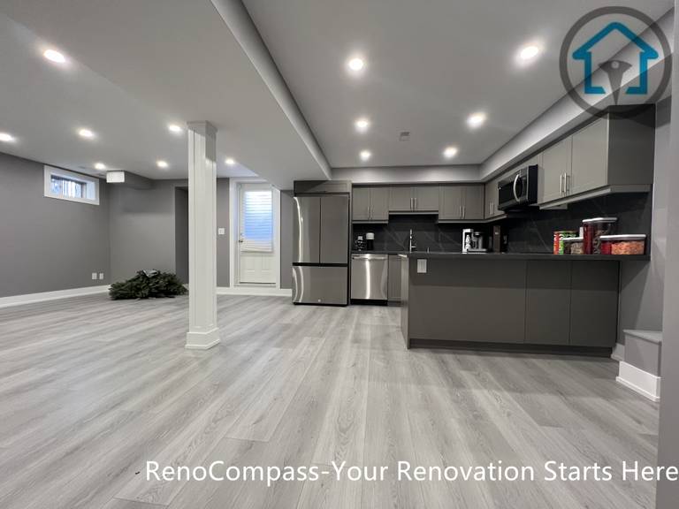 This Vaughan basement renovation showcases a spacious open-concept layout that combines a modern kitchen, dining, and living area within a cohesive lower-level design. The space features custom cabinetry, stainless steel appliances, recessed ceiling lighting, structural support columns, and durable wood-look flooring that enhances brightness and flow. Completed by a Toronto renovation company, this basement renovation emphasizes efficient space planning, modern finishes, and flexible use for everyday living or entertaining.