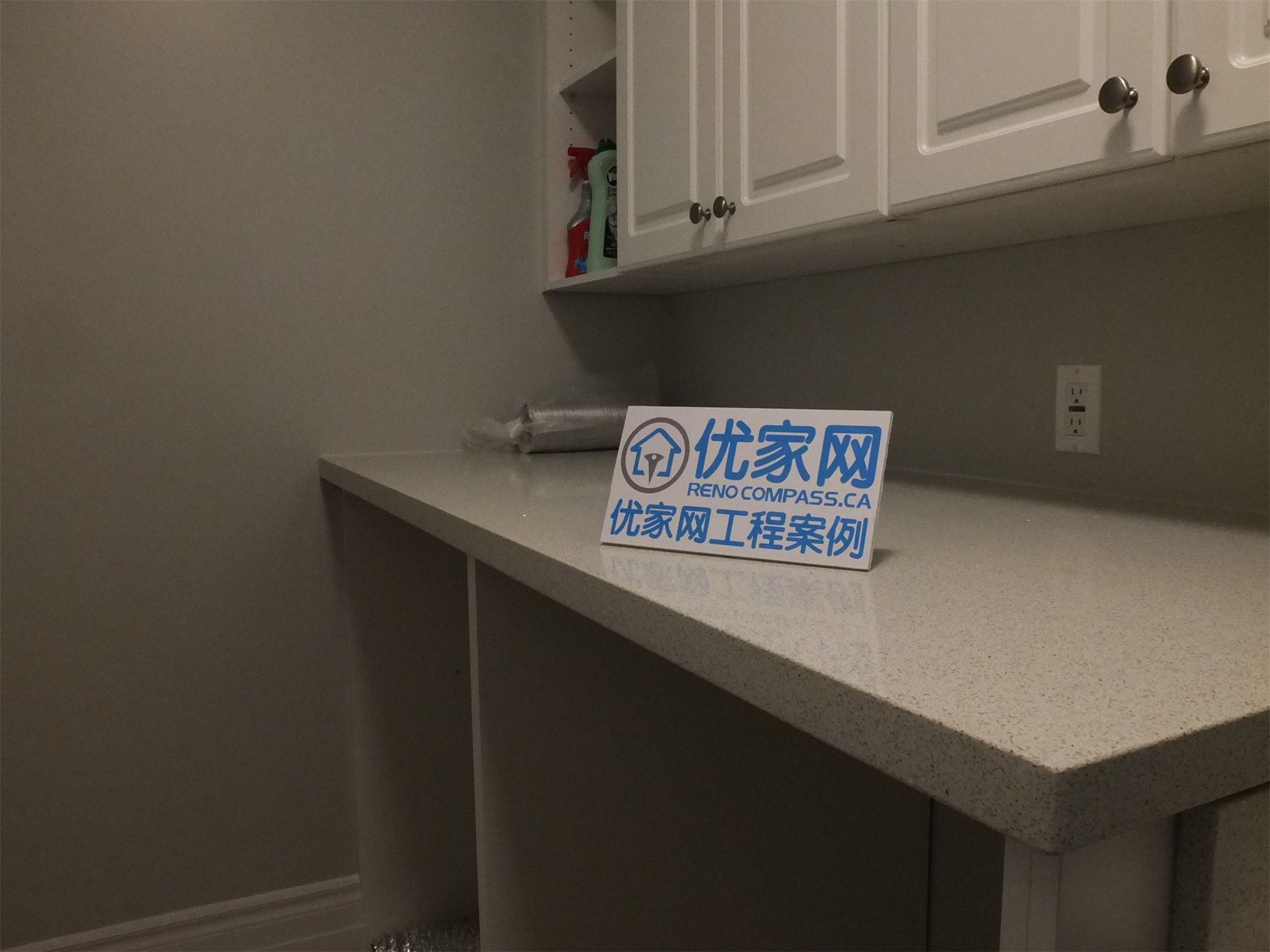 This Richmond Hill basement renovation highlights a detailed view of the utility area, featuring a quartz countertop, custom upper cabinets, and a built-in sink. The clean finishes and practical layout provide efficient storage and workspace, ideal for laundry or additional household use.