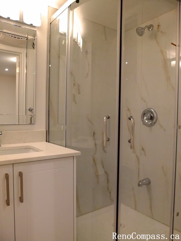 This Markham basement renovation features a modern bathroom design with a frameless glass shower enclosure, marble-look wall tiles, and a sleek white vanity with integrated sink. The bright finishes and contemporary fixtures create a clean, elegant, and highly functional basement bathroom space for homeowners in Markham.