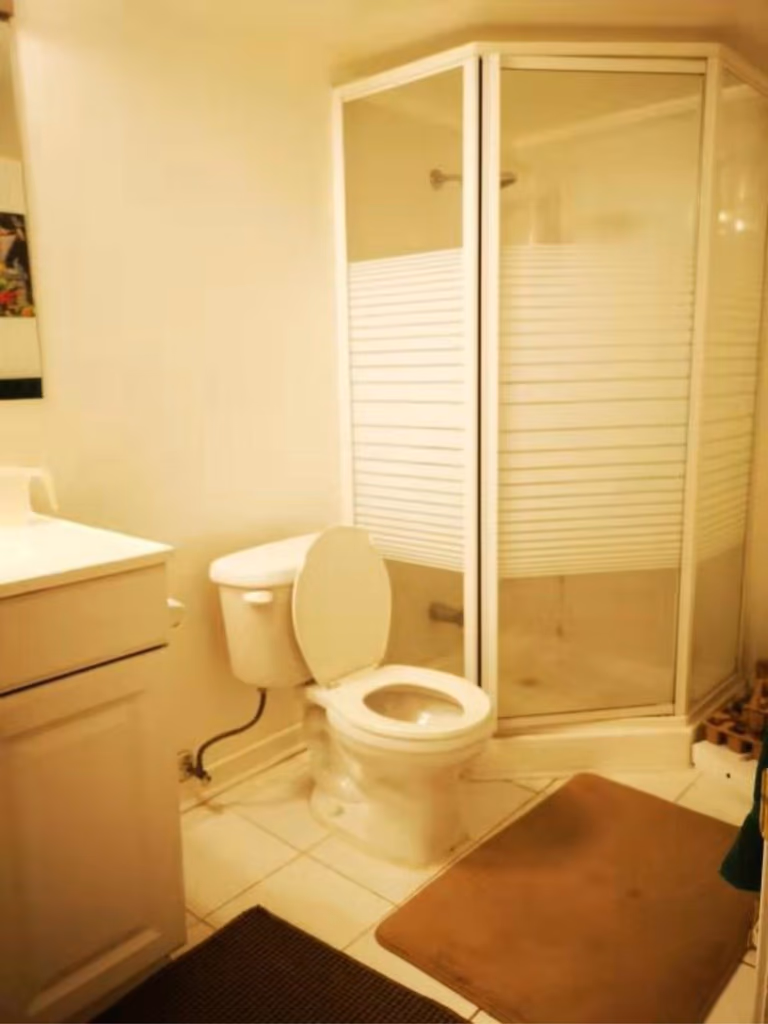 This Mississauga basement bathroom features a compact layout with a corner glass shower, standard vanity, and tiled flooring. The existing setup highlights opportunities for modern upgrades, improved lighting, and enhanced space efficiency. A professional Toronto renovation company can transform this bathroom into a sleek, functional, and contemporary space.