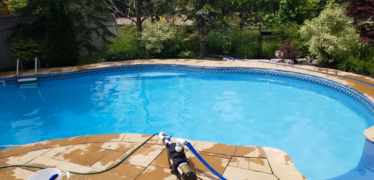 After renovation photo of a fully restored backyard swimming pool in Toronto. The new bright blue liner, clean water, and resurfaced edges highlight the professional pool transformation from old and damaged to modern and inviting. Expert pool renovation by local Toronto specialists.