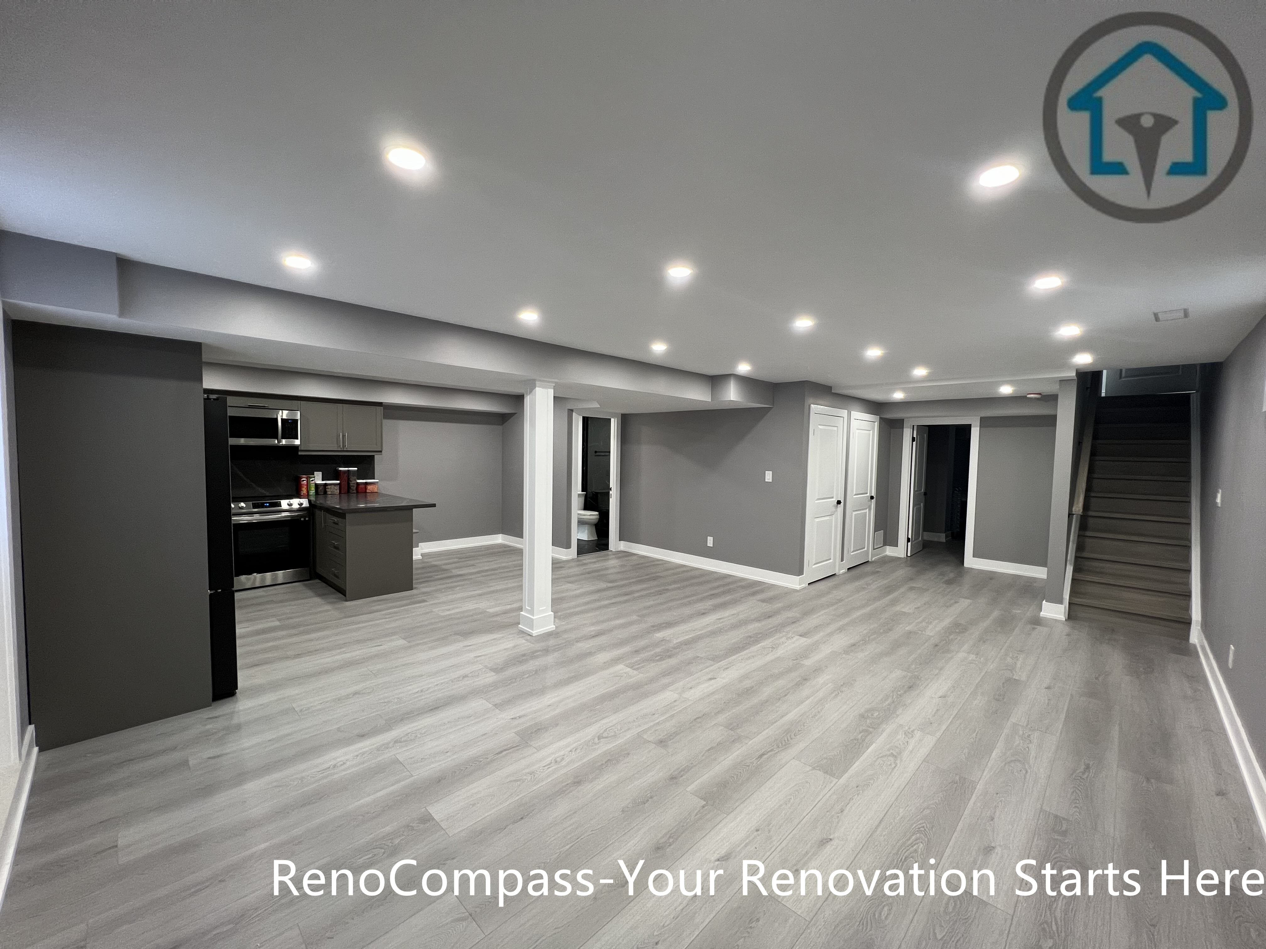 This Vaughan basement renovation features a wide open-concept layout with clear circulation, structural support columns, recessed ceiling lighting, and durable wood-look flooring. The design connects the kitchen area with flexible living and activity zones while maintaining strong structural organization and visual balance. Completed by a Toronto renovation company, this basement renovation highlights efficient space planning and modern finishes suited for multi-purpose lower-level living.