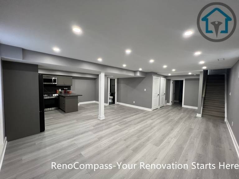 This Vaughan basement renovation features a wide open-concept layout with clear circulation, structural support columns, recessed ceiling lighting, and durable wood-look flooring. The design connects the kitchen area with flexible living and activity zones while maintaining strong structural organization and visual balance. Completed by a Toronto renovation company, this basement renovation highlights efficient space planning and modern finishes suited for multi-purpose lower-level living.