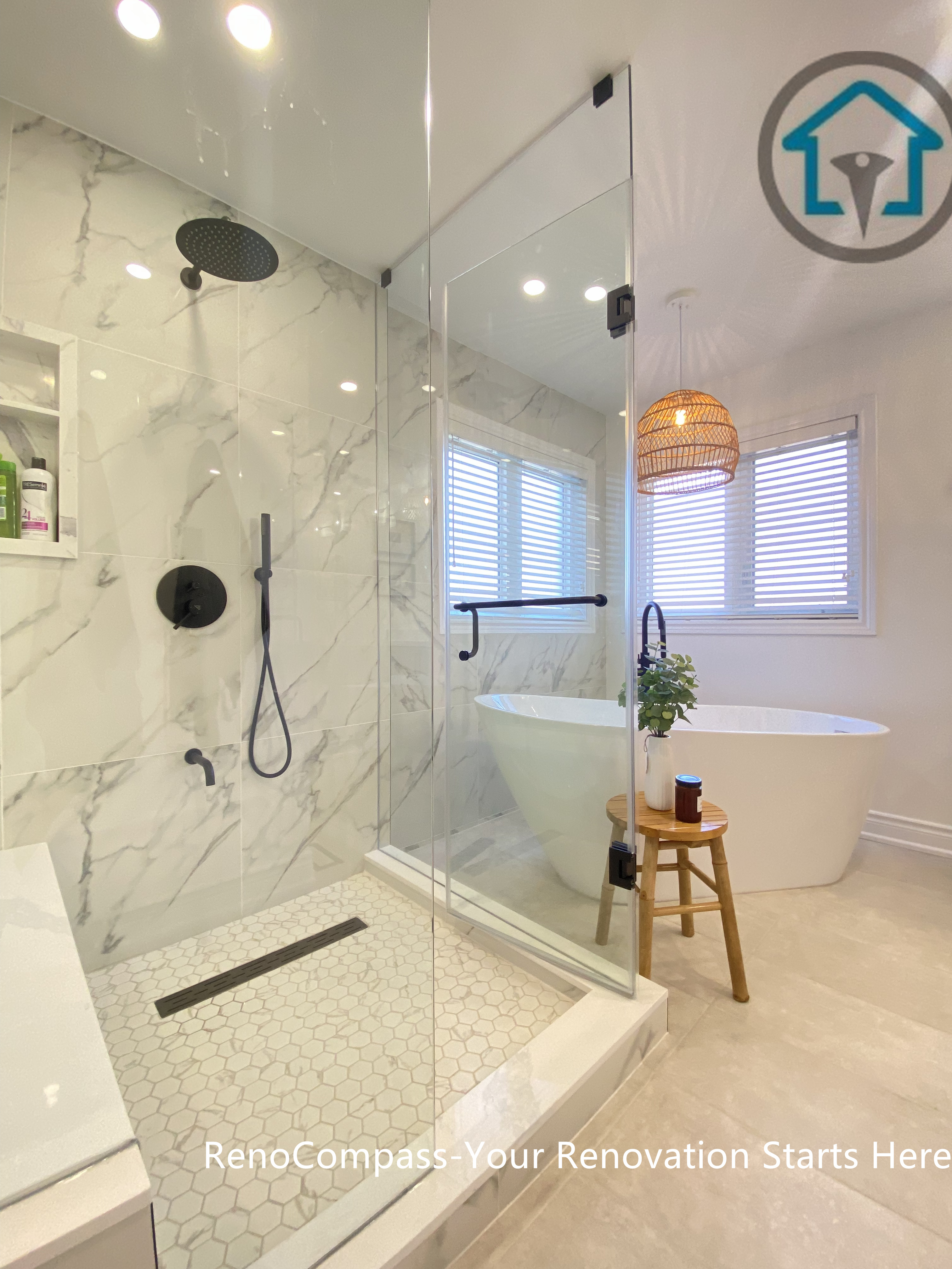Contemporary Oakville bathroom renovation showcasing a frameless glass walk-in shower, marble-look wall tiles, matte black rain shower system, and hexagon mosaic shower floor. This bathroom remodel highlights precise detailing, clean drainage design, and a modern spa-style layout completed by an experienced Toronto renovation company.