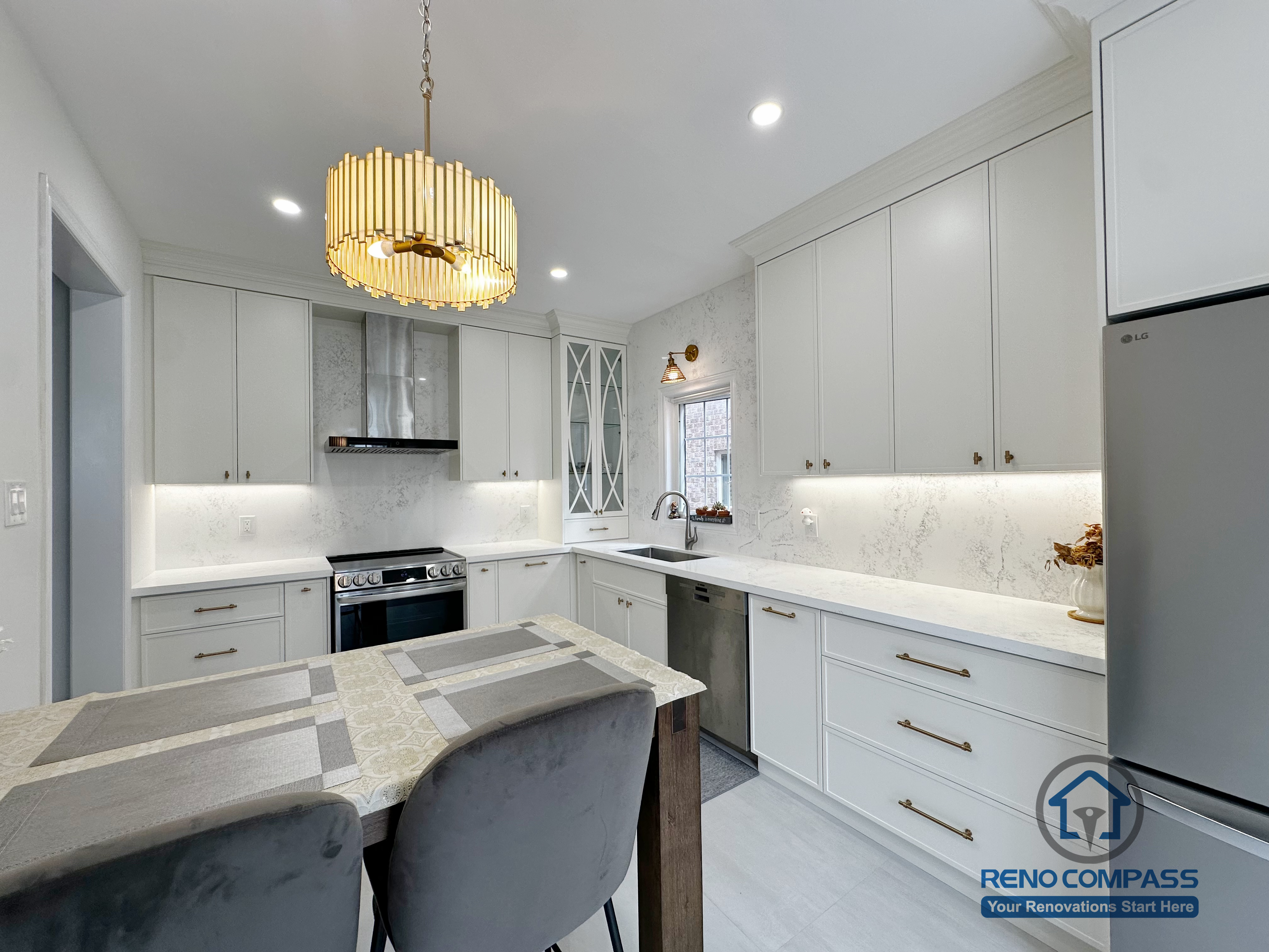 This Markham kitchen renovation features a refined, functional layout with custom white cabinetry, quartz countertops, and integrated under-cabinet lighting. The U-shaped workspace is designed for efficient daily use, while the central dining island creates a natural gathering point for family and guests. Gold-accent pendant lighting adds warmth and visual focus, complementing the clean finishes and modern appliances. The overall design balances practicality and elegance, delivering a bright, timeless kitchen tailored to contemporary living in Markham.
