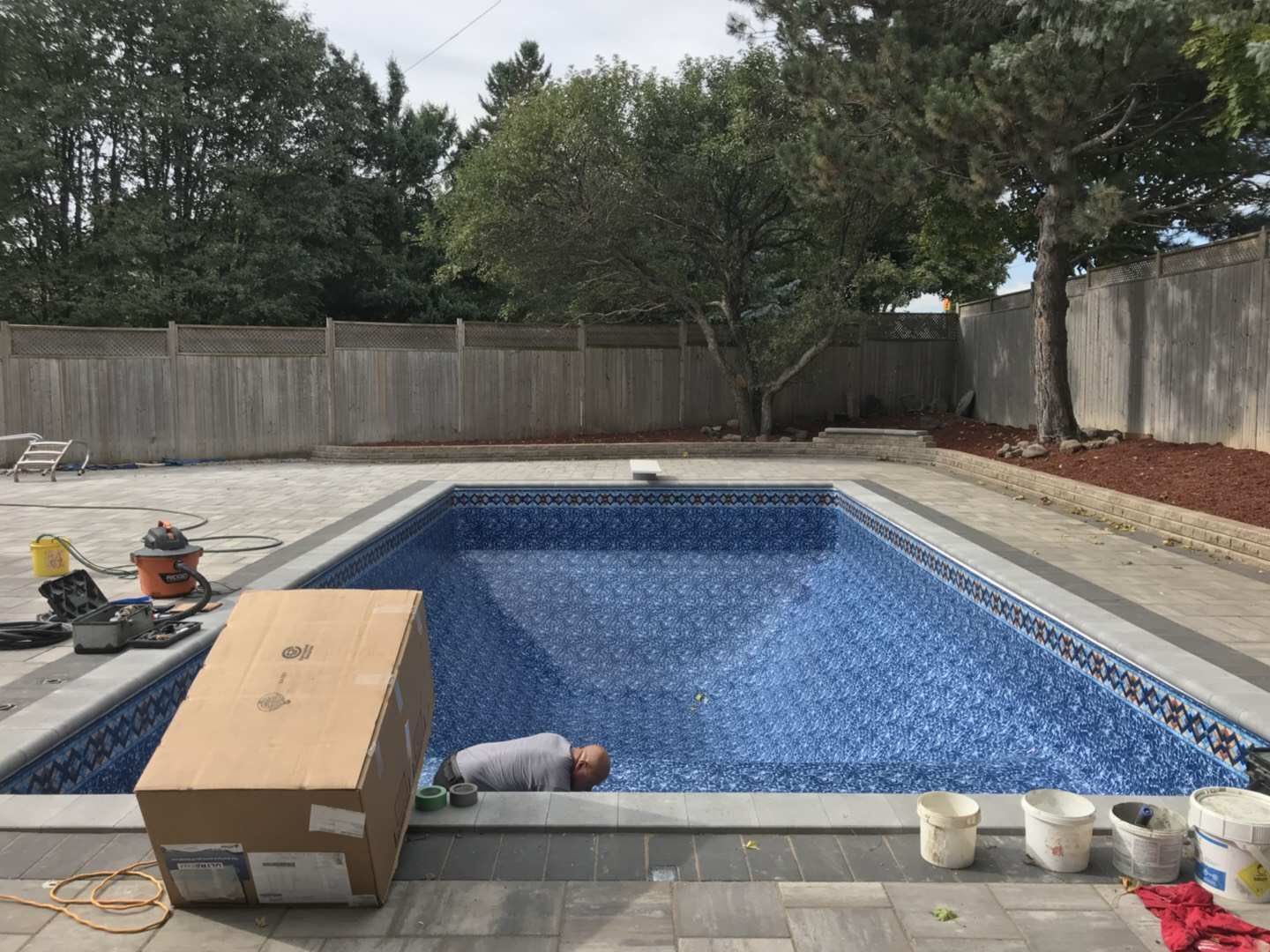 After renovation photo of a fully restored backyard swimming pool in Toronto. The new bright blue liner, clean water, and resurfaced edges highlight the professional pool transformation from old and damaged to modern and inviting. Expert pool renovation by local Toronto specialists.