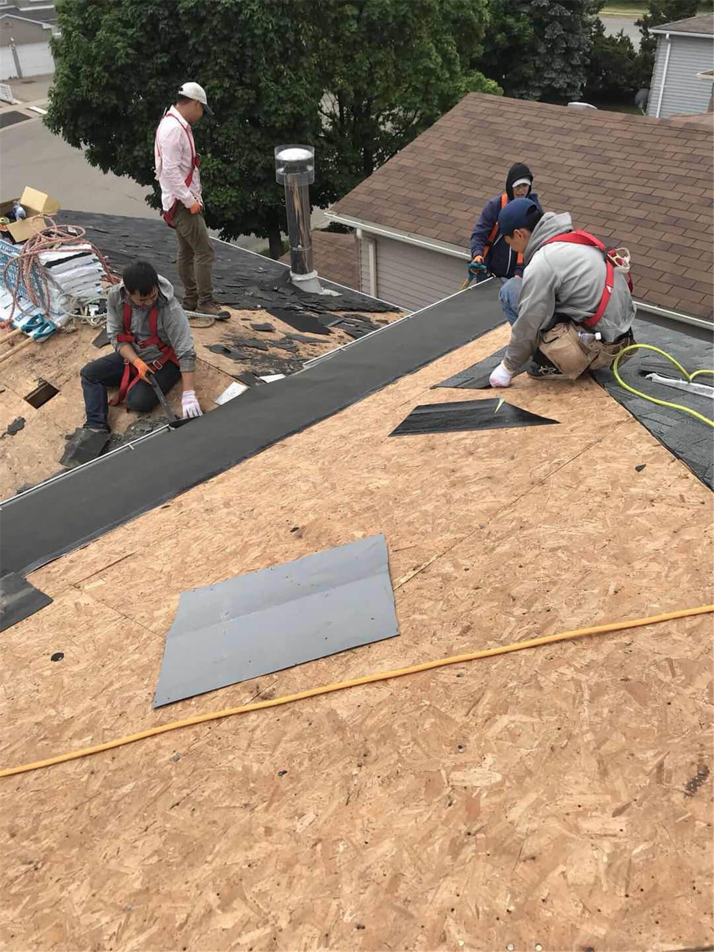 This image captures the mid-stage of a roofing replacement project in Toronto, showing newly installed roof decking and waterproof underlayment preparation. The old roofing materials have been removed to expose the wooden roof structure, allowing the team to reinforce the base and ensure proper alignment before installing new shingles. High-quality waterproof membrane layers are applied to enhance moisture protection and improve long-term durability against Toronto’s harsh weather conditions. This professional roofing replacement process ensures structural integrity, proper insulation support, and a reliable foundation for the final roofing system installation on residential properties.