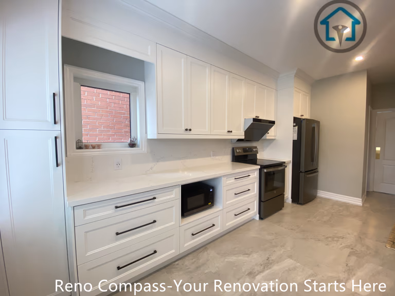 This image highlights the main working wall of the Markham kitchen renovation, featuring full-height white cabinetry designed to maximize storage and maintain a clean, cohesive look.