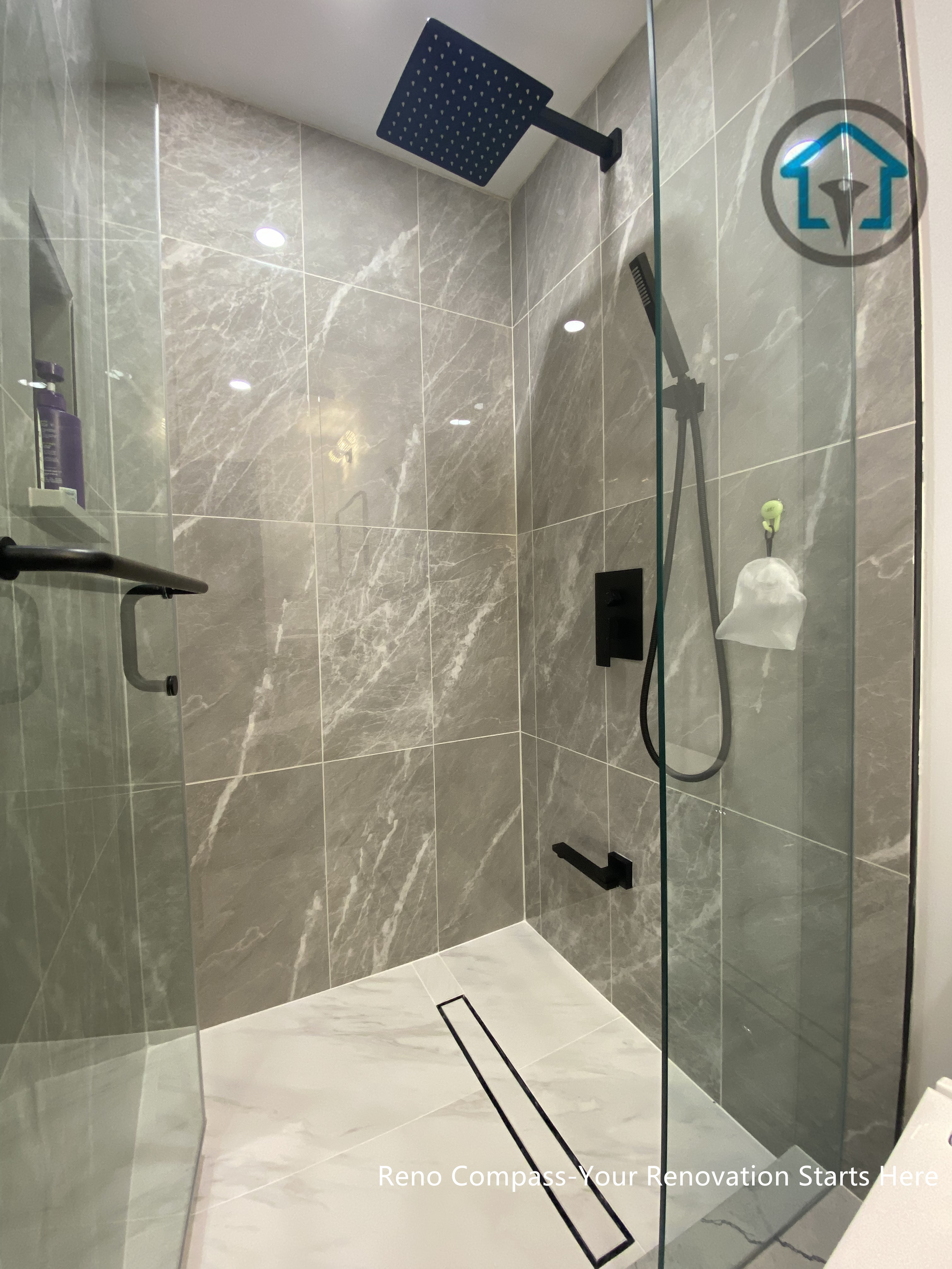 This bathroom renovation in Toronto features a modern walk-in glass shower designed for both comfort and durability. Large-format stone-look tiles create a seamless and calming backdrop, while matte black fixtures add contrast and visual clarity. The curbless shower base and linear drain enhance accessibility and ease of maintenance, supporting long-term daily use. Clean detailing and balanced proportions result in a refined shower space that blends functionality with understated elegance.