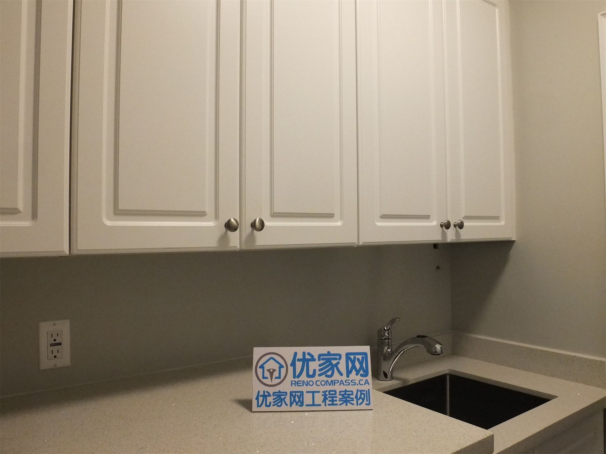 This Richmond Hill basement renovation includes a functional kitchen area featuring custom cabinetry, a built-in sink, and a clean tile backsplash. The light-colored cabinets combined with modern hardware create a bright and practical space, ideal for a basement bar, secondary kitchen, or rental suite setup.