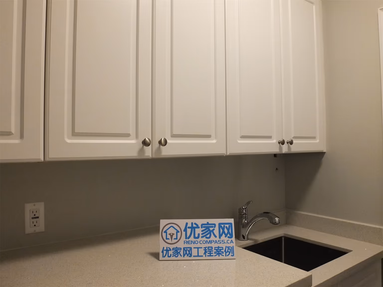 This Richmond Hill basement renovation includes a functional kitchen area featuring custom cabinetry, a built-in sink, and a clean tile backsplash. The light-colored cabinets combined with modern hardware create a bright and practical space, ideal for a basement bar, secondary kitchen, or rental suite setup.