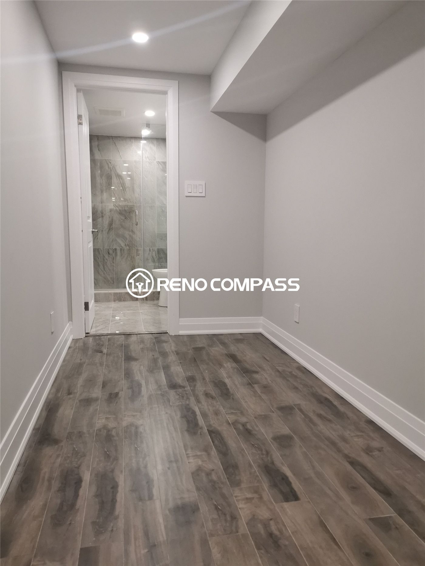 This Markham basement renovation project showcases newly installed waterproof vinyl flooring, modern recessed pot lights, and a clean hallway leading to a fully upgraded bathroom. The space was redesigned to improve durability, brightness, and everyday functionality, creating a comfortable and low-maintenance basement environment. Completed by a professional Toronto renovation company, the project highlights quality flooring installation, precise finishing, and modern basement remodeling tailored for long-term residential use in the Greater Toronto Area.