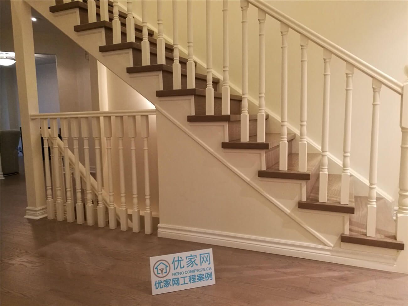 This image presents a side profile view of a completed staircase flooring renovation in North York, highlighting hardwood stair treads paired with white railings and balusters. The clean lines of the staircase structure and the consistent wood flooring across the lower level create a cohesive and polished interior appearance. Careful detailing at the stair stringer and baseboard transitions enhances both durability and visual balance. This North York flooring renovation showcases precise installation and craftsmanship by a professional Toronto renovation company specializing in residential flooring and staircase renovations.