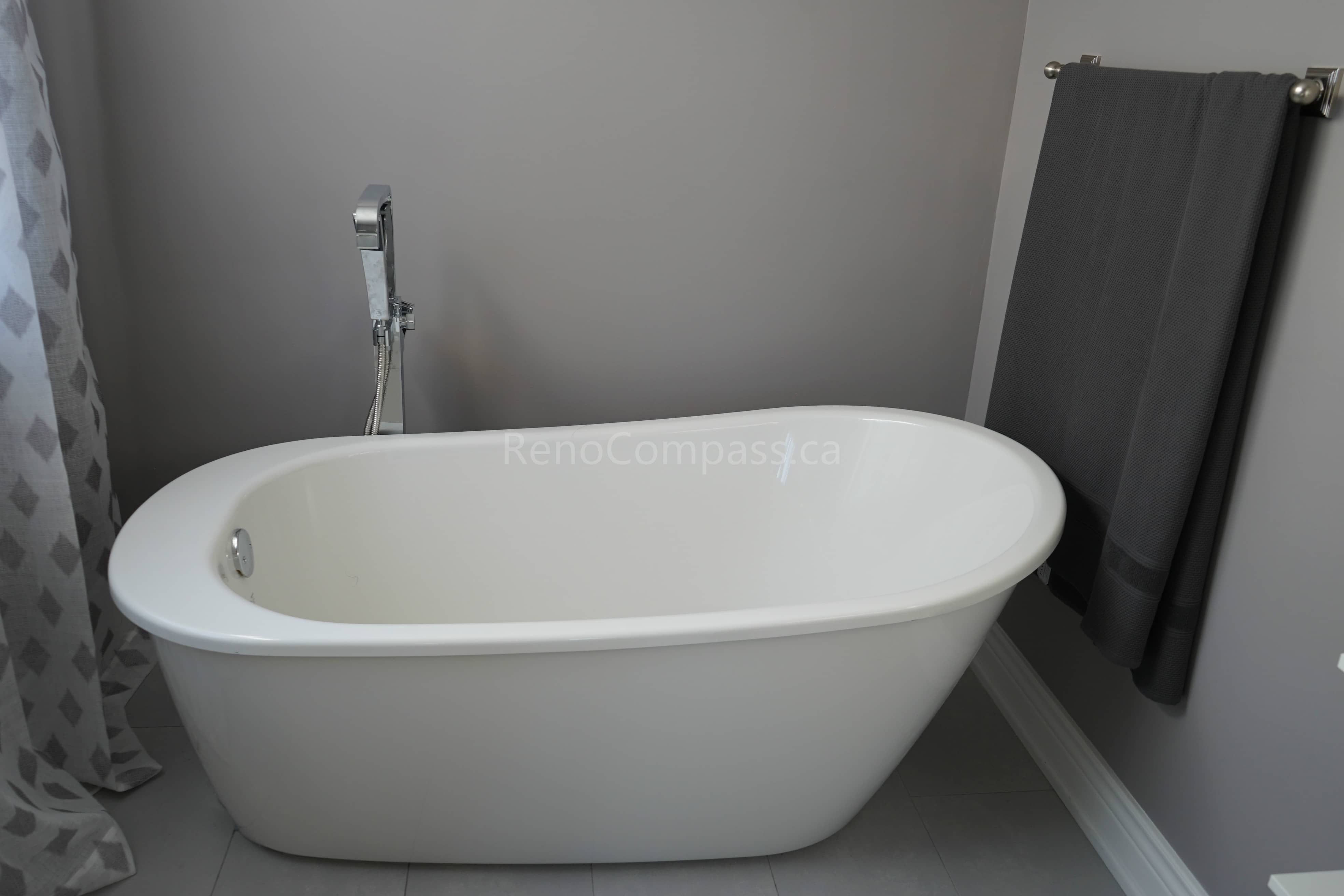 This bathroom renovation showcases a sleek freestanding bathtub paired with modern fixtures and neutral wall tones. The minimalist design creates a spa-like atmosphere, offering homeowners a relaxing and elegant bathing space while enhancing the overall value and comfort of the home.