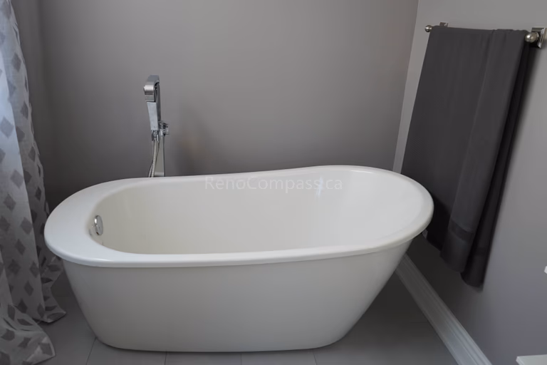 This bathroom renovation showcases a sleek freestanding bathtub paired with modern fixtures and neutral wall tones. The minimalist design creates a spa-like atmosphere, offering homeowners a relaxing and elegant bathing space while enhancing the overall value and comfort of the home.