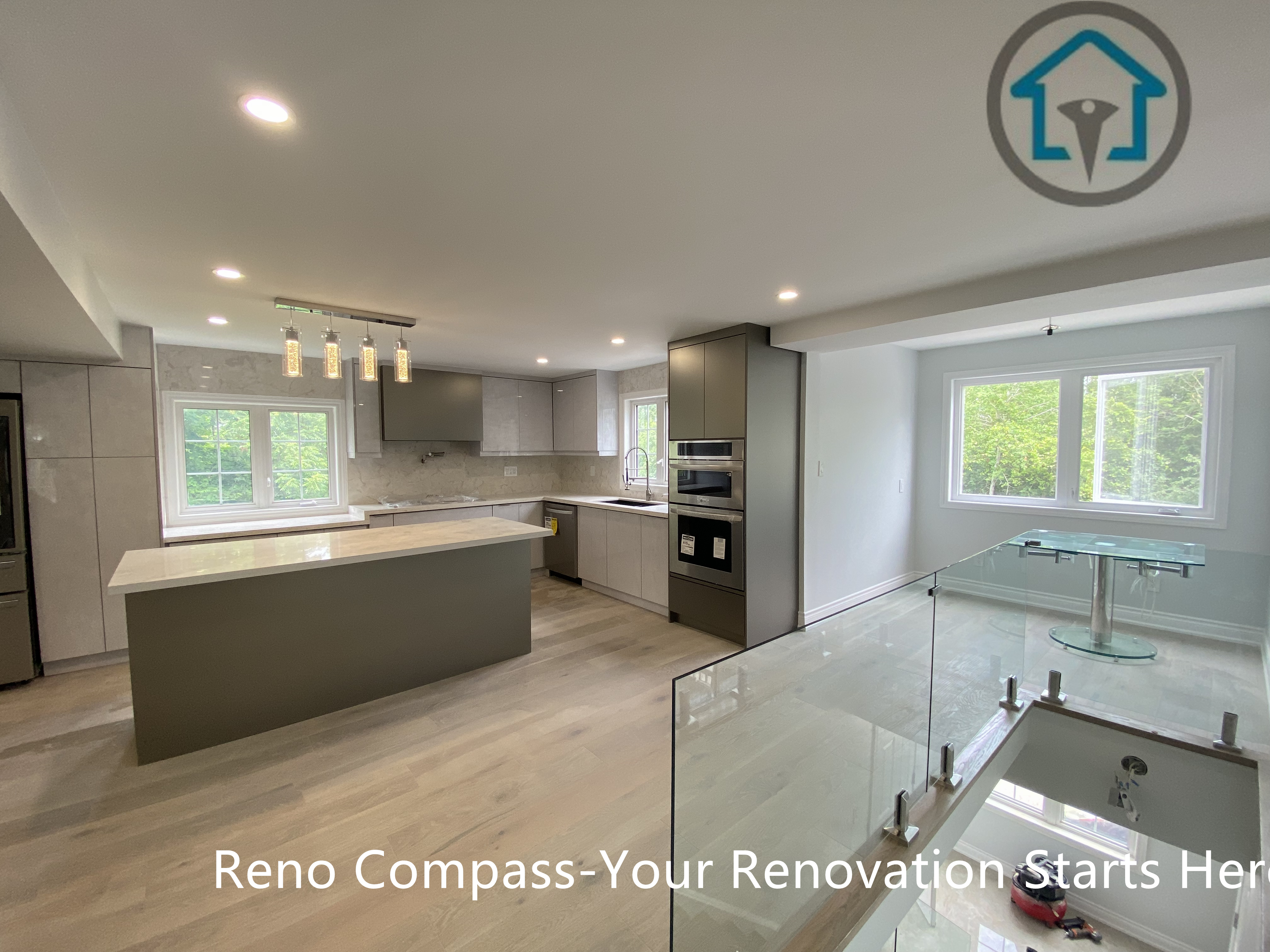 This Stouffville kitchen renovation features a spacious open-concept layout with a large waterfall island, custom grey cabinetry, integrated stainless steel appliances, and layered recessed lighting. The design emphasizes clean lines, efficient workflow, and natural light, creating a highly functional and contemporary family kitchen.