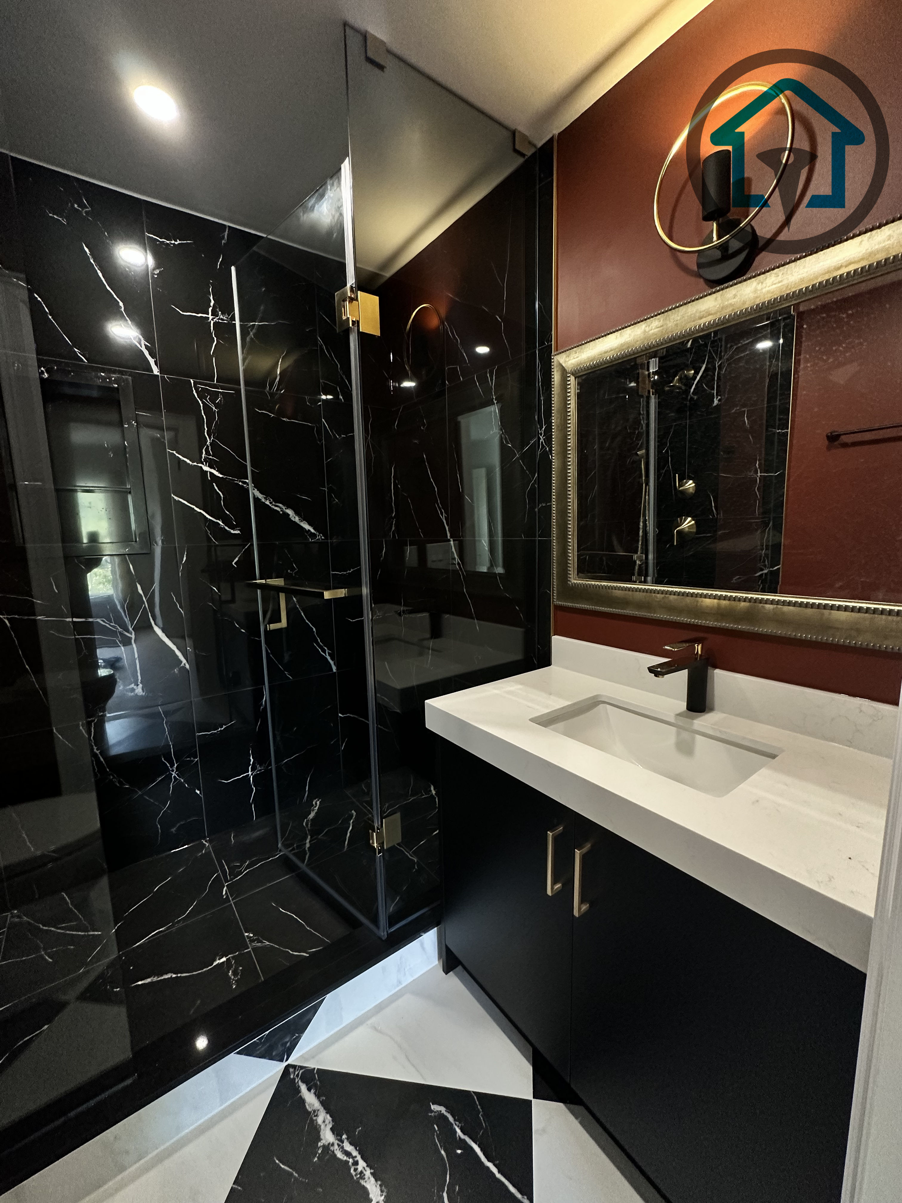 This modern powder room was completed as part of a North York interior renovation project, featuring a sleek black marble walk-in shower, custom vanity cabinetry, and a bold contrast between dark stone surfaces and warm accent walls. Clean glass panels, integrated lighting, and refined material selection enhance both functionality and visual impact, delivered by a professional Toronto renovation company experienced in full interior renovations.
