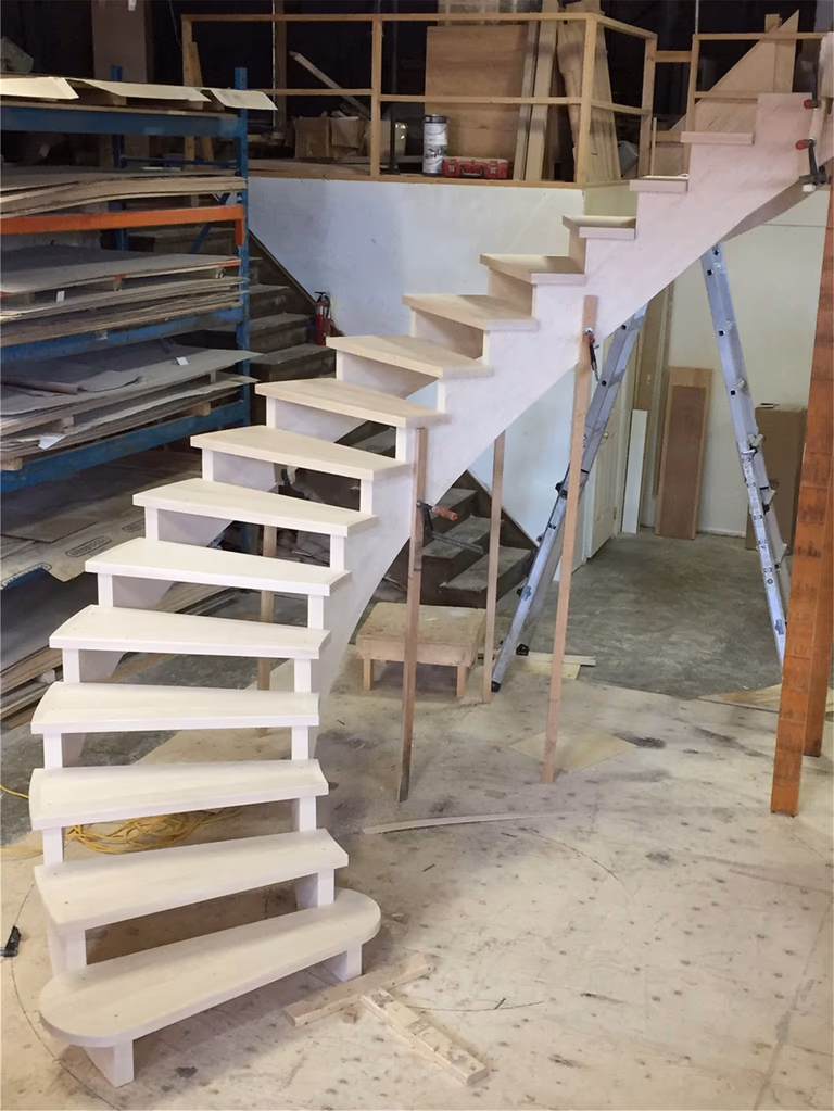 This image showcases a custom curved staircase under construction as part of a Toronto stair renovation project. The staircase features precisely crafted hardwood treads and a smooth curved structure designed for both durability and architectural elegance. Professional framing and careful step alignment ensure structural stability and a refined finish. As an experienced Toronto Renovation Company, Reno Compass Inc. delivers high-quality staircase renovation solutions that enhance both safety and interior aesthetics for homes across the Greater Toronto Area.