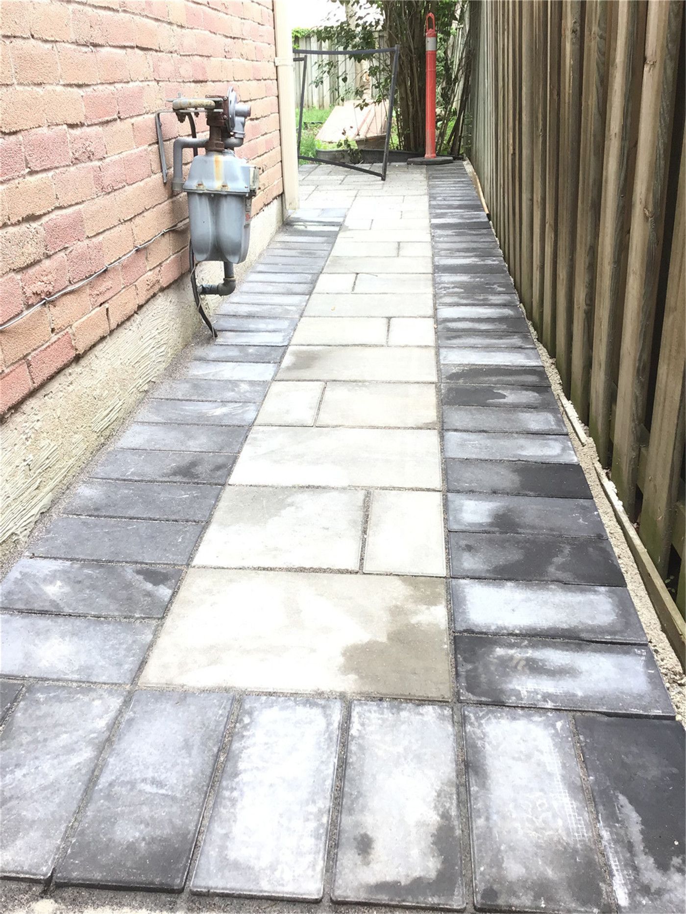 This Oakville interlocking project showcases a clean and functional side walkway built with durable grey pavers and a contrasting dark border design. Installed along the side of the home, the pathway improves drainage, accessibility, and overall property maintenance. The precise layout and professional finish create a sleek, low-maintenance solution ideal for narrow side yard spaces.