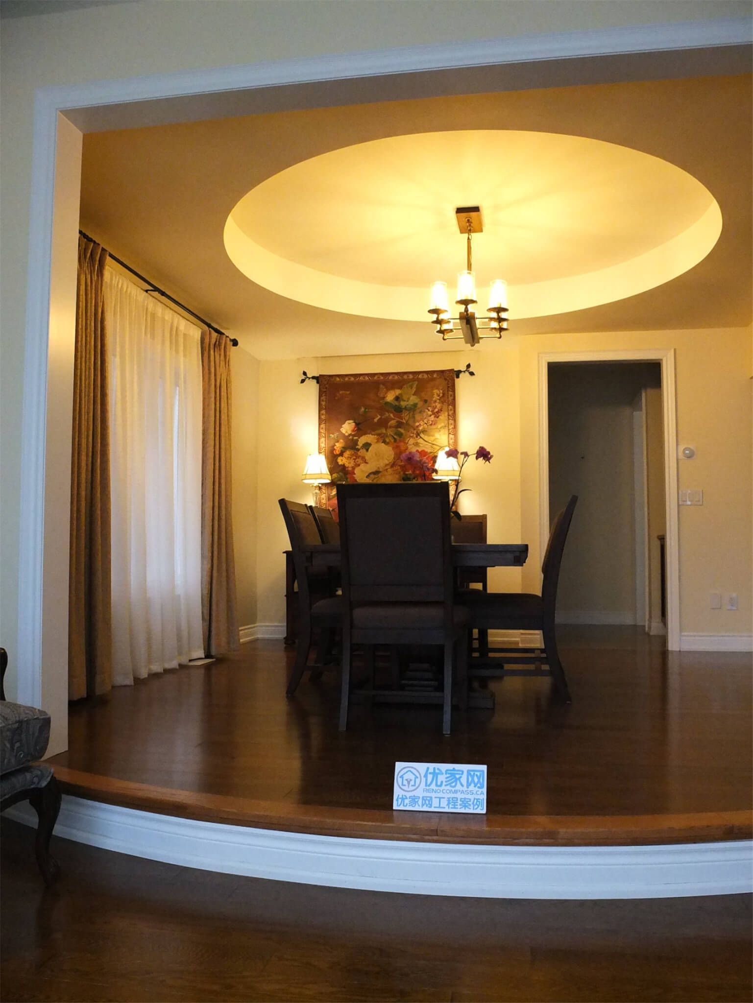 This Aurora flooring renovation highlights a beautifully upgraded dining room featuring rich hardwood flooring and elegant interior details. The polished wood floor complements the elevated dining area, curved step design, and warm ceiling lighting, creating a sophisticated and inviting atmosphere. Completed by a professional Toronto renovation company, the flooring installation enhances both the visual appeal and durability of this refined dining space.