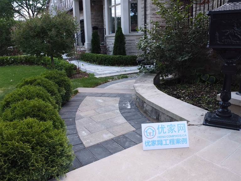 This North York landscaping renovation highlights a curved front walkway designed to guide movement through landscaped garden areas toward the home entrance. Interlocking stone pavers were arranged in a flowing pattern with contrasting borders, creating both visual interest and safe, comfortable walking surfaces. The pathway integrates seamlessly with planting beds, lawn edges, and retaining wall elements, ensuring proper grading, drainage, and long-term durability. This front garden walkway reflects a refined hardscape solution that enhances curb appeal while maintaining functional circulation for residential properties in North York.