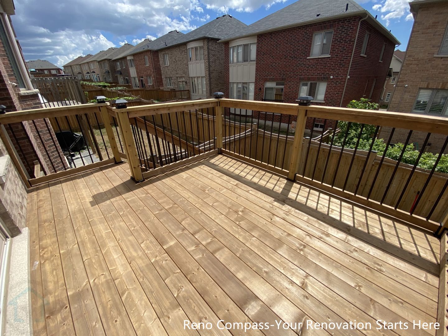 This Markham outdoor renovation features a custom-built raised wooden deck designed for outdoor relaxation and everyday use. Pressure-treated wood decking provides a durable, weather-resistant surface, while black metal railings add safety and a clean, modern contrast to the natural wood finish. The elevated deck creates an inviting outdoor space with clear sightlines and seamless connection to the backyard below. Precise construction and balanced proportions ensure long-term performance and visual consistency. This deck and patio project was completed by Reno Compass, serving homeowners in Markham and across the GTA.