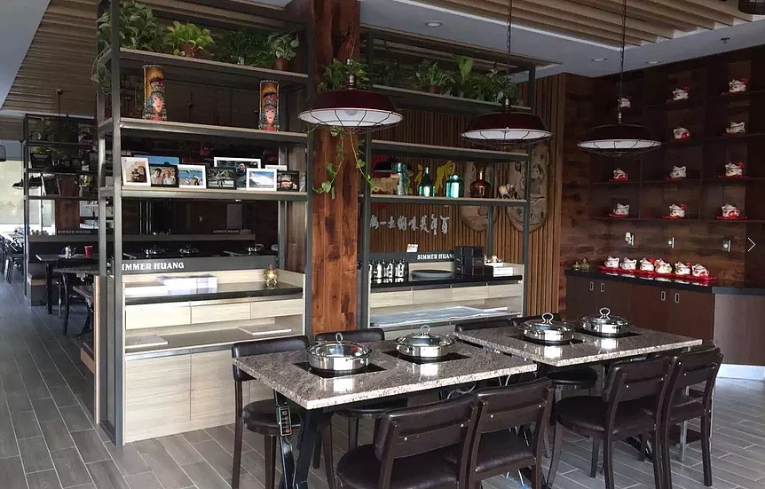This Markham restaurant renovation by Reno Compass Inc. features a beautifully designed dining area with custom shelving displays, warm wood finishes, and modern pendant lighting. The space combines functional dining tables with built-in storage and decorative elements to create a welcoming and stylish restaurant atmosphere. Durable commercial flooring and thoughtful layout planning ensure both comfort for guests and efficiency for daily restaurant operations.