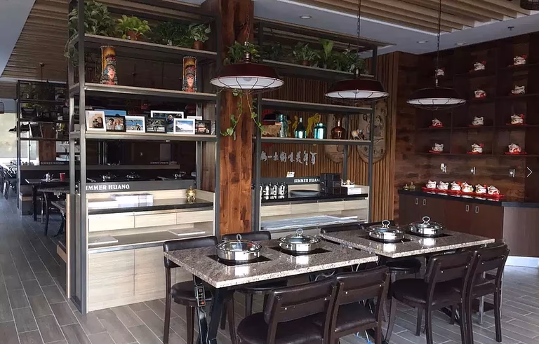 This Markham restaurant renovation by Reno Compass Inc. features a beautifully designed dining area with custom shelving displays, warm wood finishes, and modern pendant lighting. The space combines functional dining tables with built-in storage and decorative elements to create a welcoming and stylish restaurant atmosphere. Durable commercial flooring and thoughtful layout planning ensure both comfort for guests and efficiency for daily restaurant operations.
