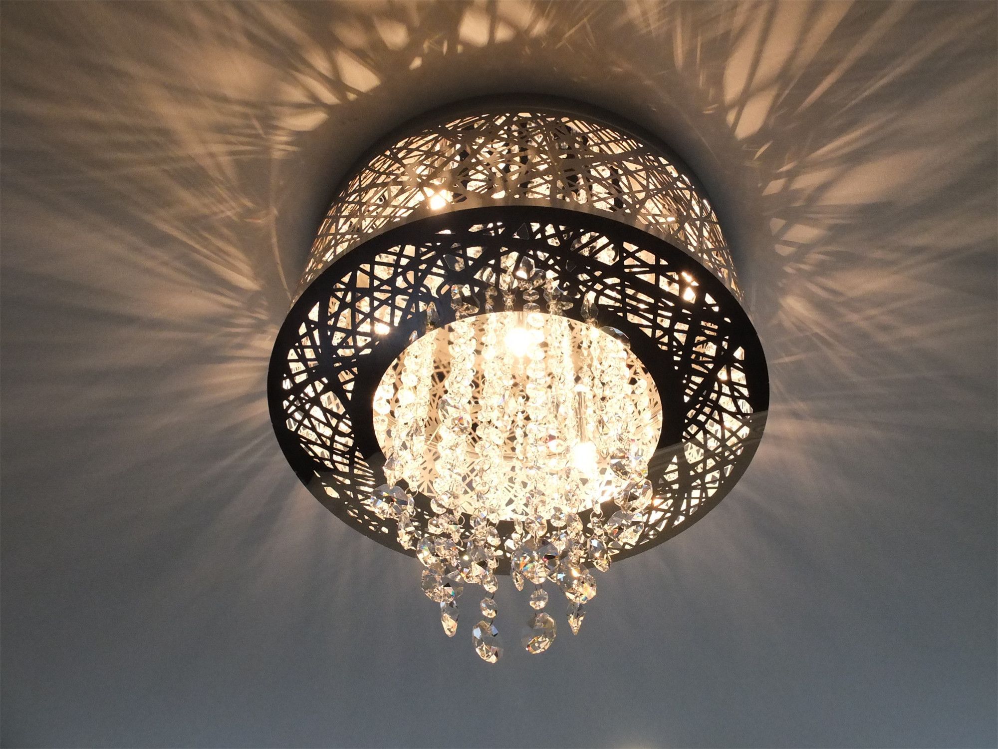 This Kleinburg interior renovation highlights a decorative crystal ceiling light fixture that adds elegance and visual texture to the room. The intricate metal frame and hanging crystal elements create beautiful light reflections across the ceiling, enhancing the ambiance of the space. This refined lighting detail complements the modern interior design while bringing a touch of luxury to the renovated home.