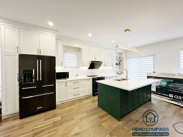 Interior renovation in Markham showcasing a modern kitchen with custom white cabinetry, a contrasting dark green island, quartz countertops, and integrated lighting. The open layout enhances functionality, flow, and everyday family use.