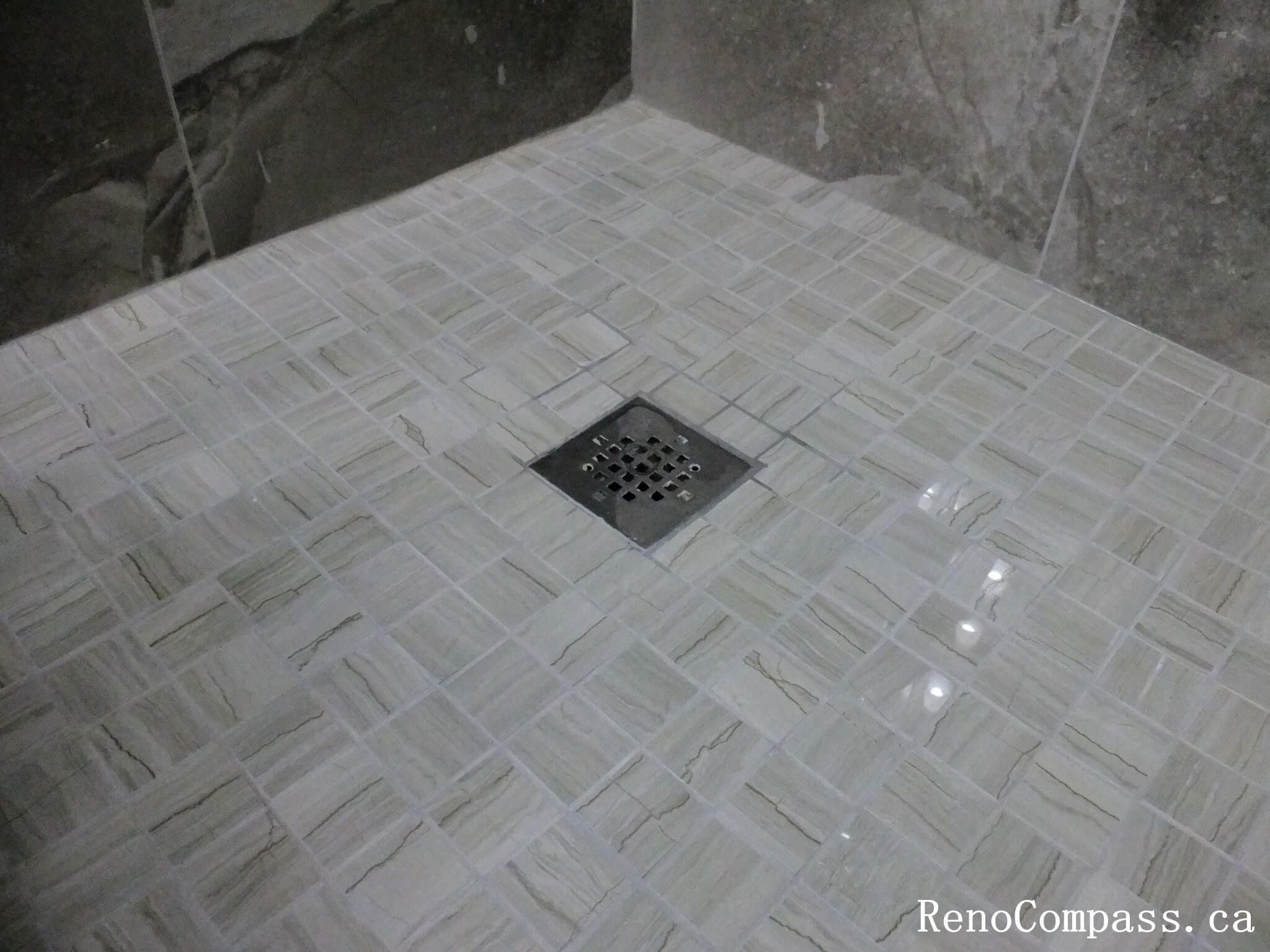 Bathroom renovation in North York highlighting a tiled shower floor with center drain, slip-resistant mosaic tiles, and precise slope installation. This Toronto interior renovation emphasizes proper drainage, waterproofing details, and long-term performance in wet-area construction.