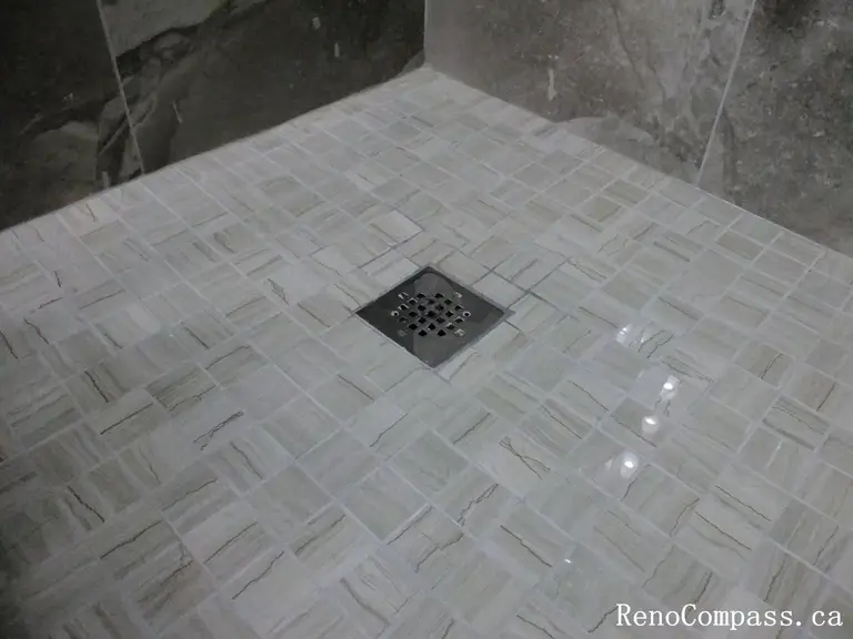 Bathroom renovation in North York highlighting a tiled shower floor with center drain, slip-resistant mosaic tiles, and precise slope installation. This Toronto interior renovation emphasizes proper drainage, waterproofing details, and long-term performance in wet-area construction.