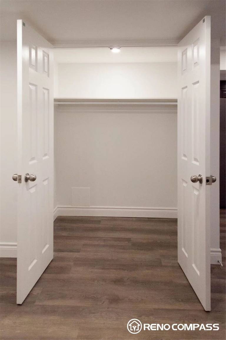 This Markham basement renovation features a clean and functional walk-in closet space designed to maximize storage and organization. The project includes newly installed double doors, fresh neutral wall finishes, modern flooring, and upgraded lighting to create a bright and practical storage area. The open closet layout allows for flexible shelving and hanging space, making the basement more livable and organized. Completed by Reno Compass Inc., this basement renovation in Markham focuses on both functionality and clean modern design, enhancing everyday usability while maintaining a polished interior look.