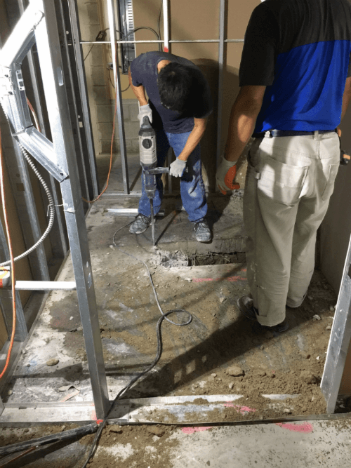 This image shows the early construction phase of a commercial retail store renovation, including floor excavation and underground plumbing preparation. The renovation team is performing structural groundwork to support new drainage, utility lines, and flooring installation for the upgraded retail space. Reno Compass Inc. ensures all foundational and infrastructure work is completed with precision to support a safe, durable, and high-quality commercial renovation.