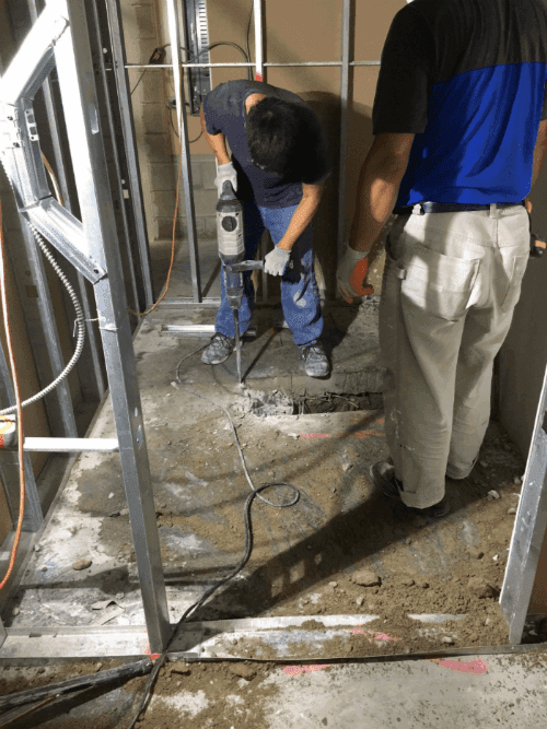 This image shows the early construction phase of a commercial retail store renovation, including floor excavation and underground plumbing preparation. The renovation team is performing structural groundwork to support new drainage, utility lines, and flooring installation for the upgraded retail space. Reno Compass Inc. ensures all foundational and infrastructure work is completed with precision to support a safe, durable, and high-quality commercial renovation.